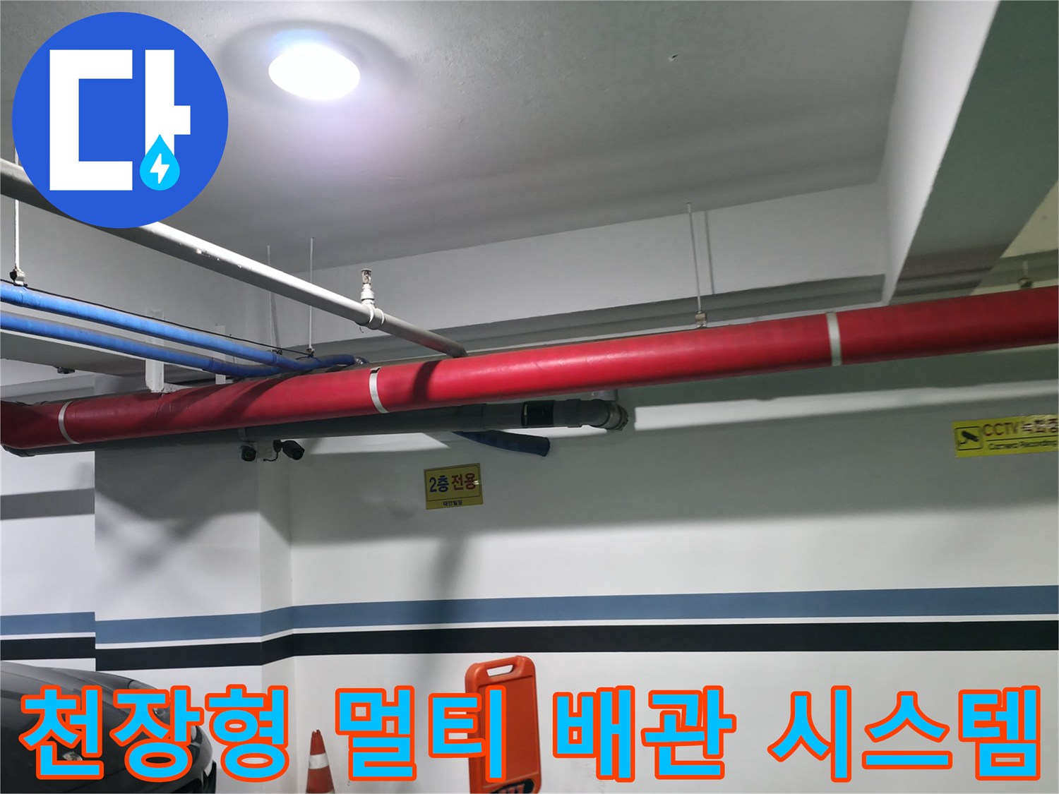 주차장 천장에 설치된 대규모 노출 파이프라인과 표시판