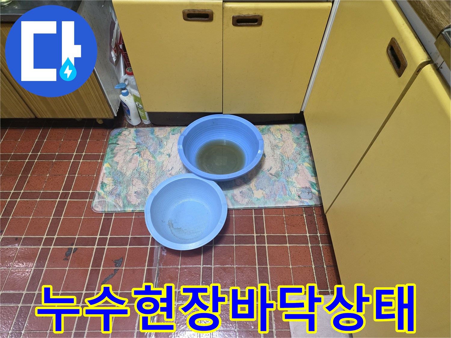누수 지점의 물을 받기 위해 설치된 파란색 대야와 매트