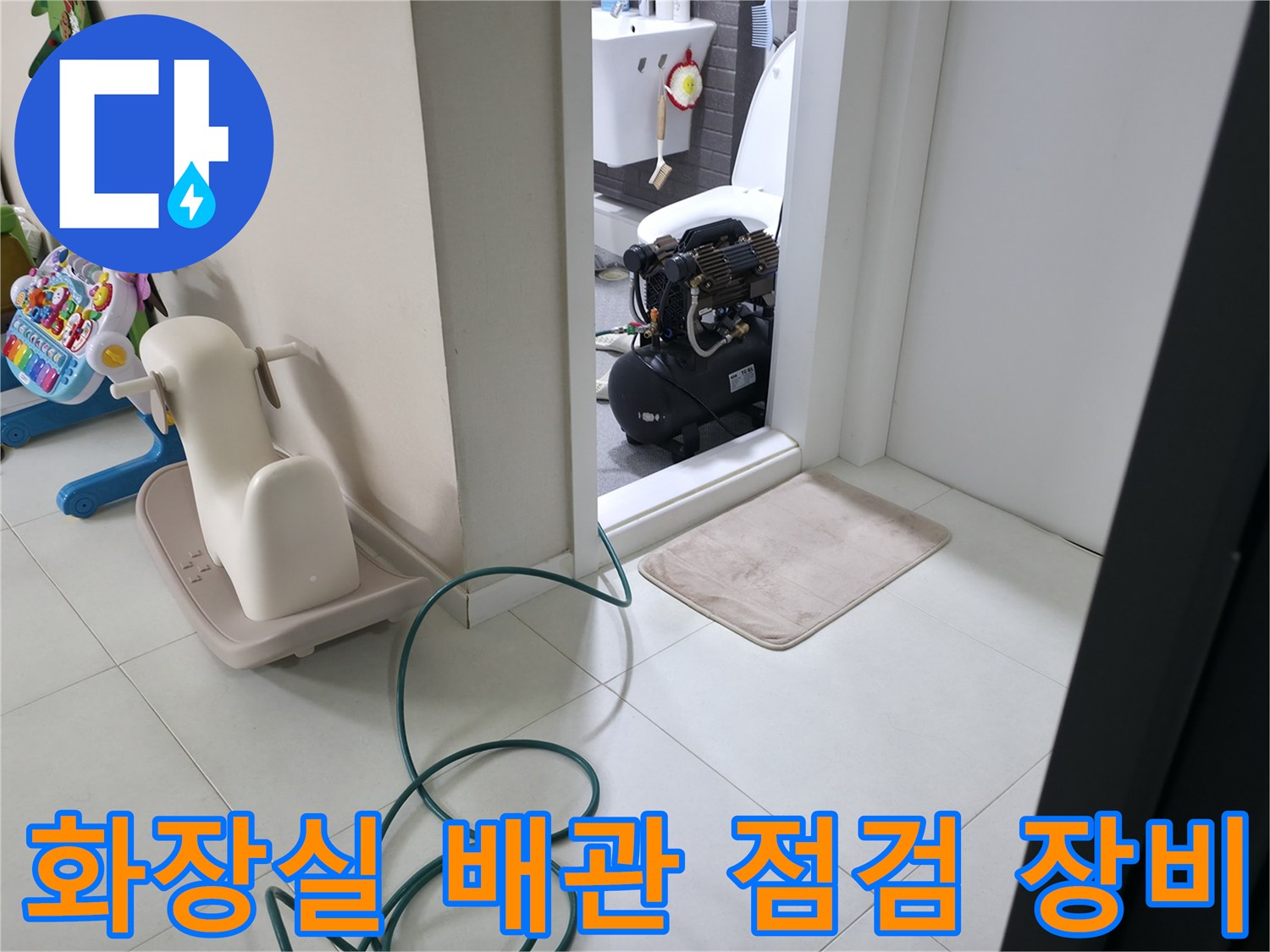 화장실 문턱 근처에 놓인 공압 테스트용 장비와 호스