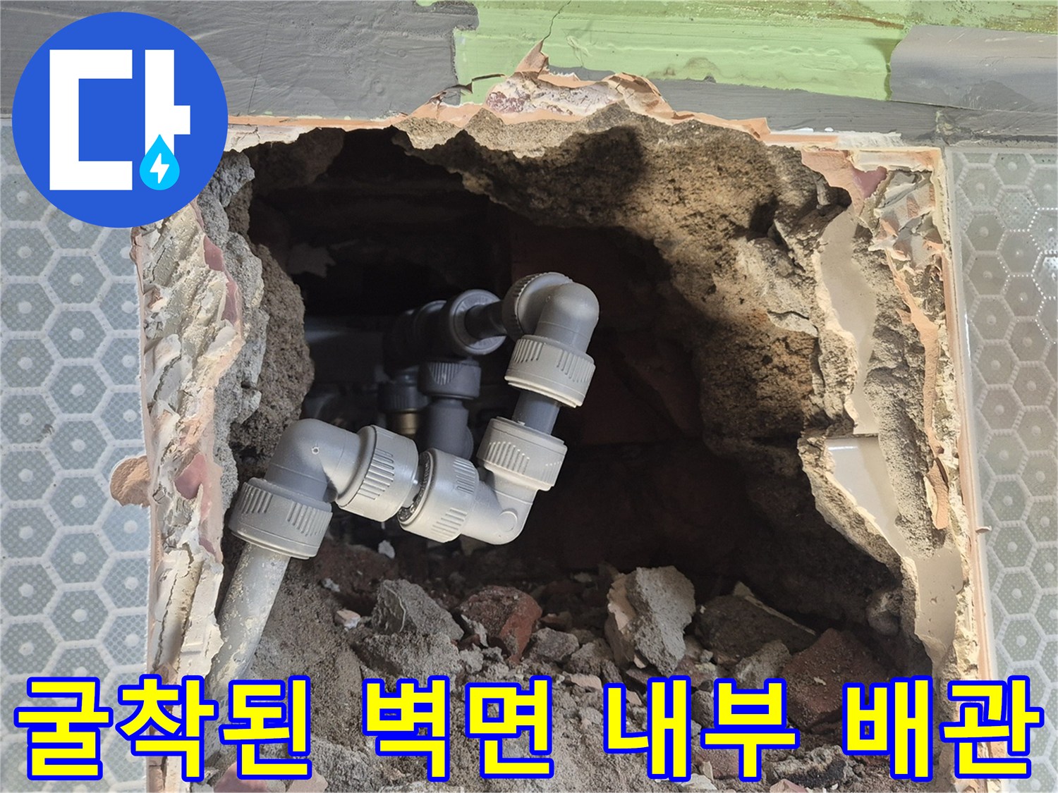 벽면 타일 안쪽의 부식된 배관을 제거하고 교체 중인 현장 상황
