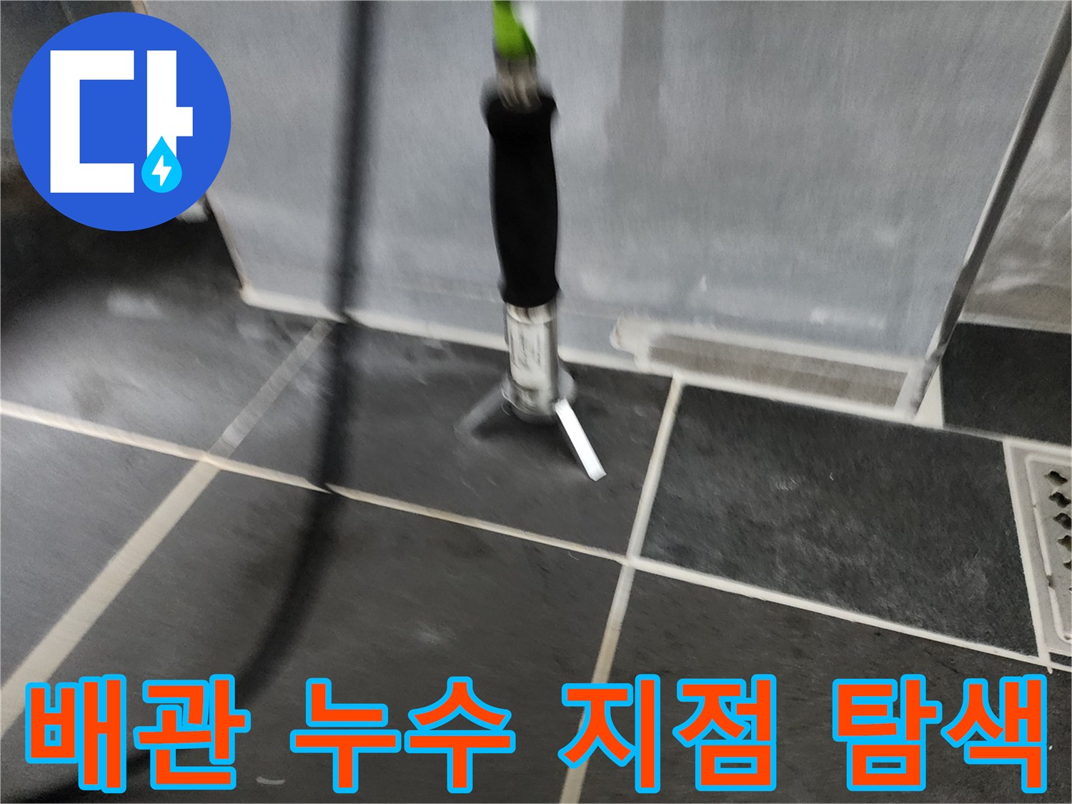 검은색 배관과-회색 타일 바닥 사이의-누수 탐지기 사용 장면