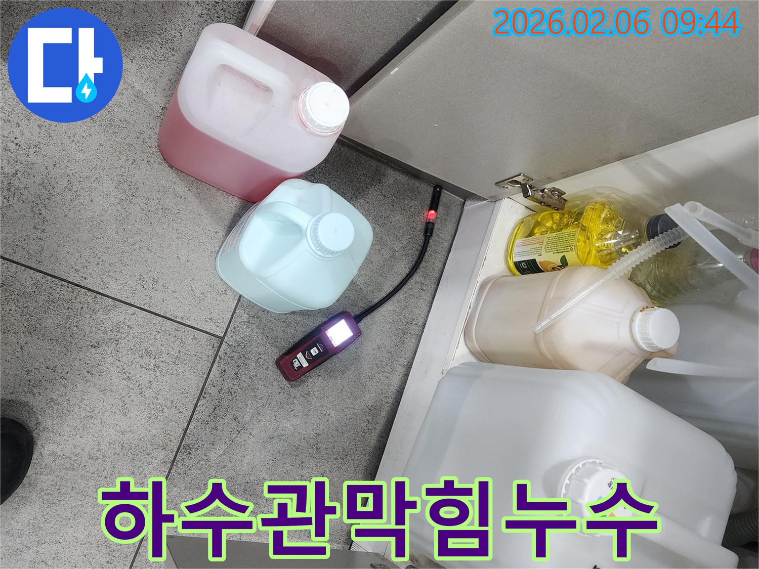 아파트 주방 싱크대 아래에서 누수탐지 장비가 하수관 막힘으로 인한 누수 동반 여부를 점검하고 있습니다