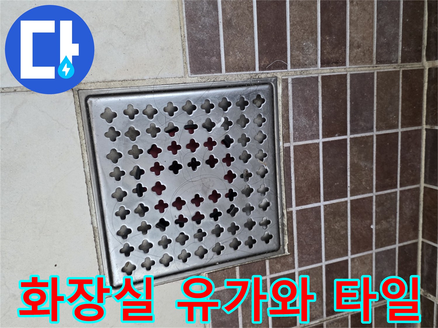 정사각형 모양의 스테인리스 배수구 덮개와 갈색 타일 벽면