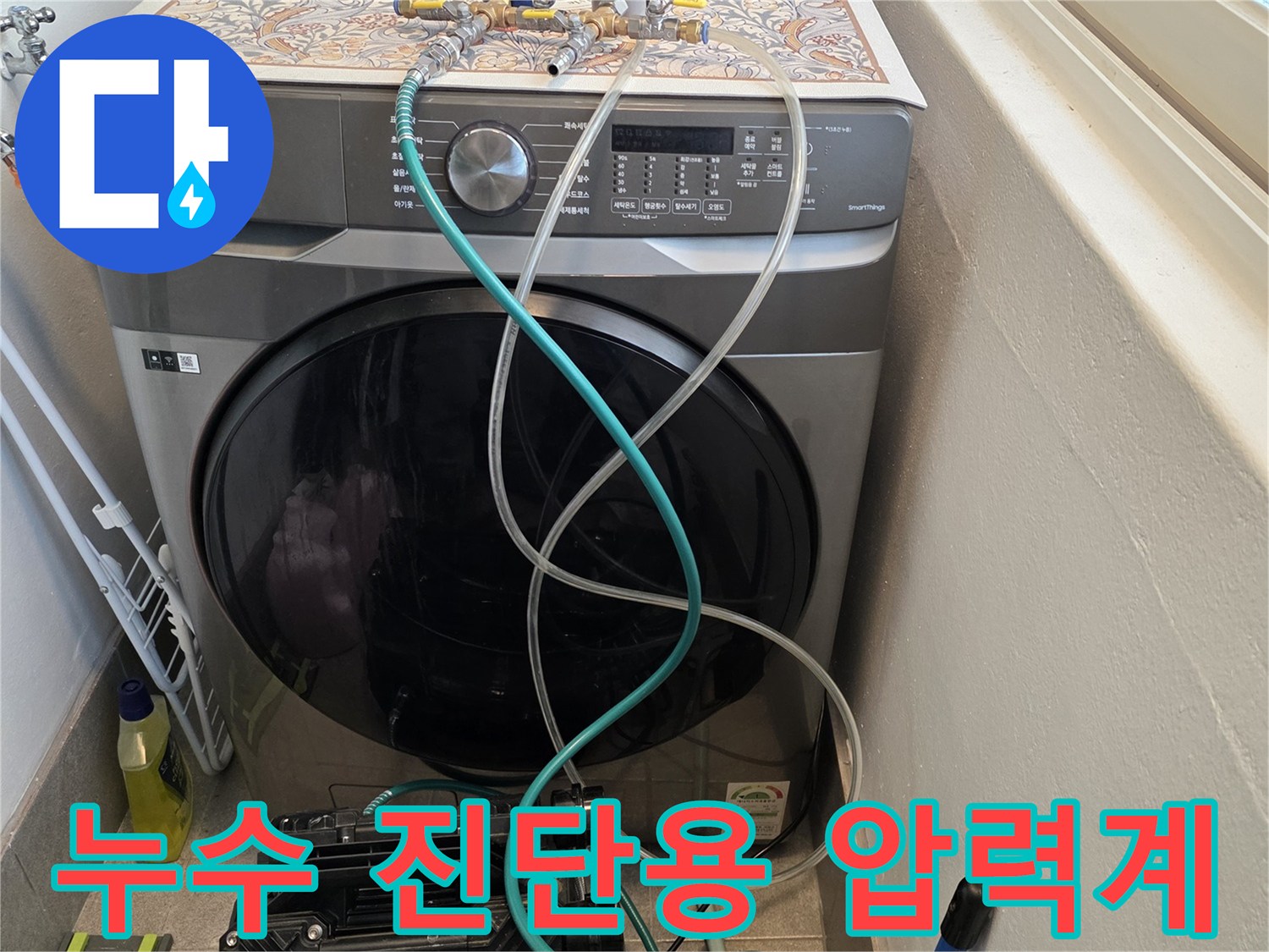 세탁기 뒤 배관에 연결된 공압 테스트 장비 모습