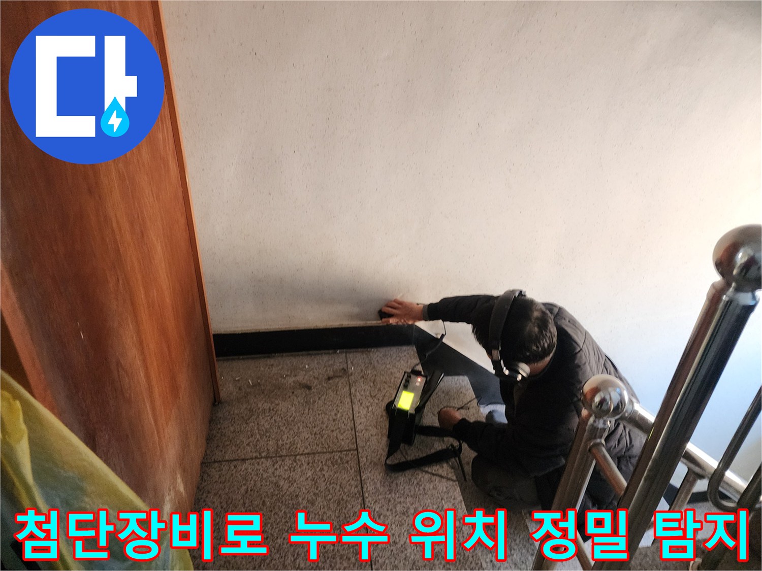 전문가용 가스 탐지기를 활용하여 벽면과 바동 경계 부근의 배관 누수 지점을 찾아내는 장면