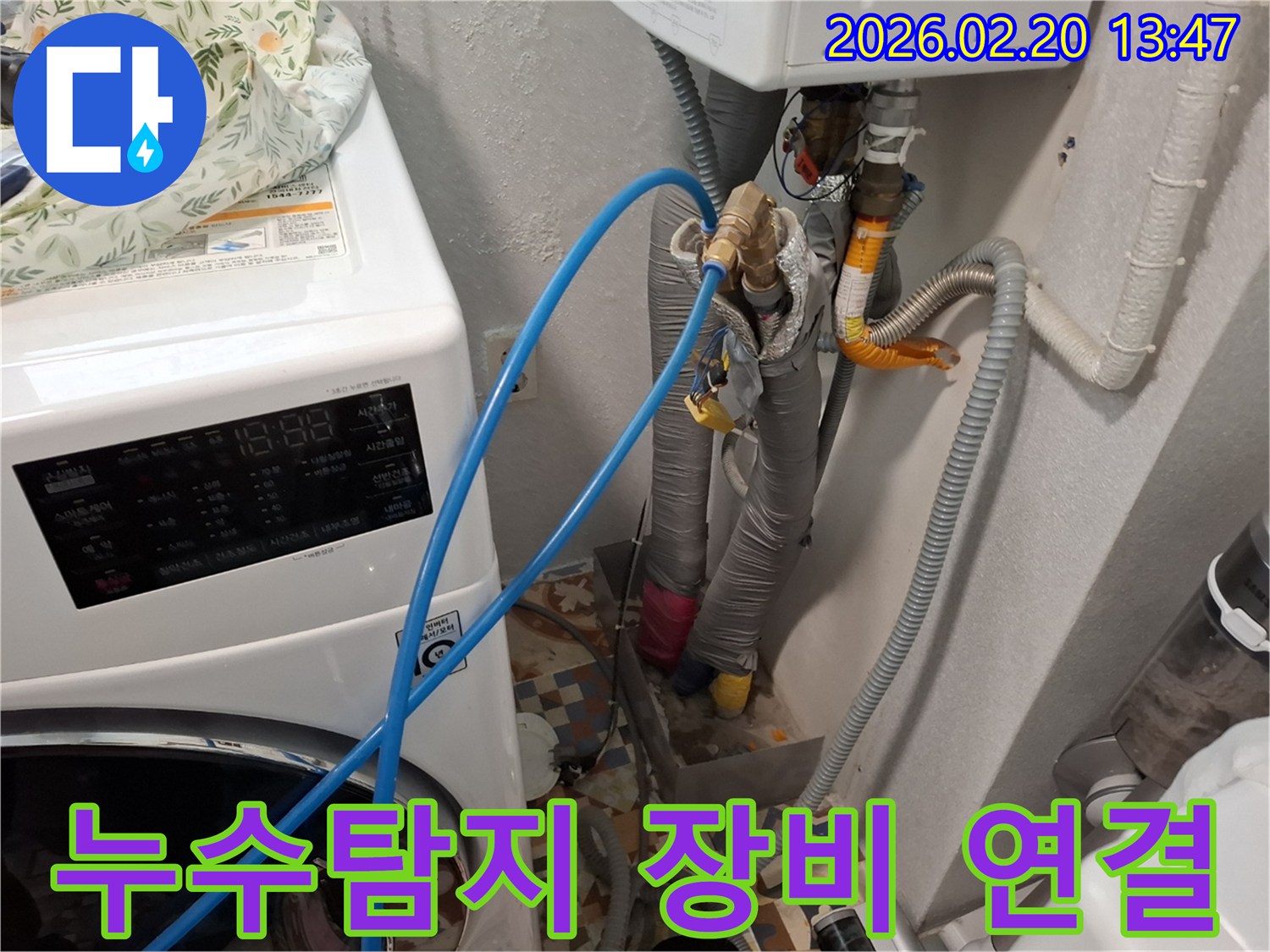 세탁기 옆 배관에-누수탐지용 파란 호스를 연결하여-정밀 검사를 준비하는 모습