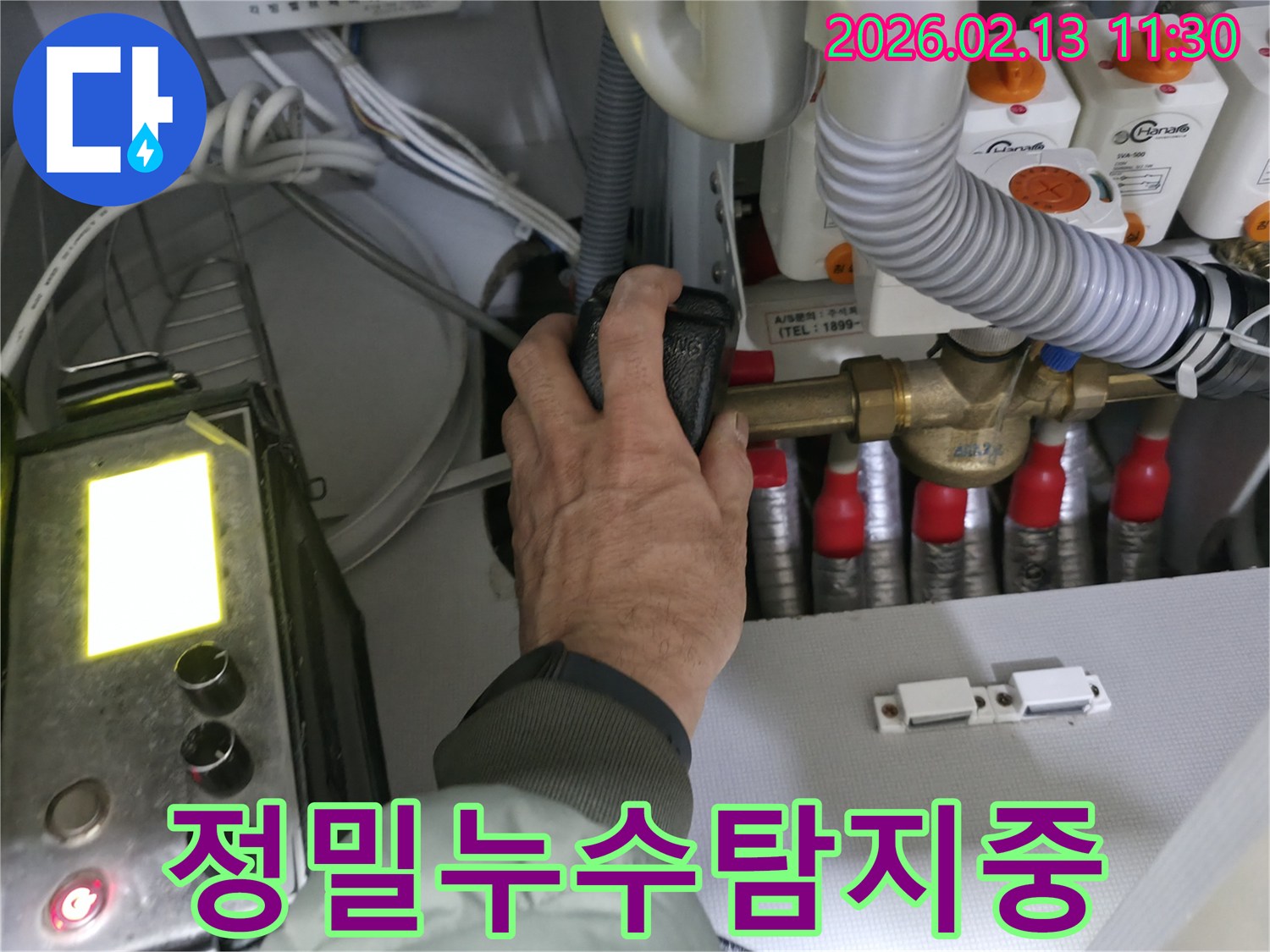 누수 전문 엔지니어가-온수 배관 밸브를-세밀하게 조작하며-누수 지점을 탐지하는-모습입니다