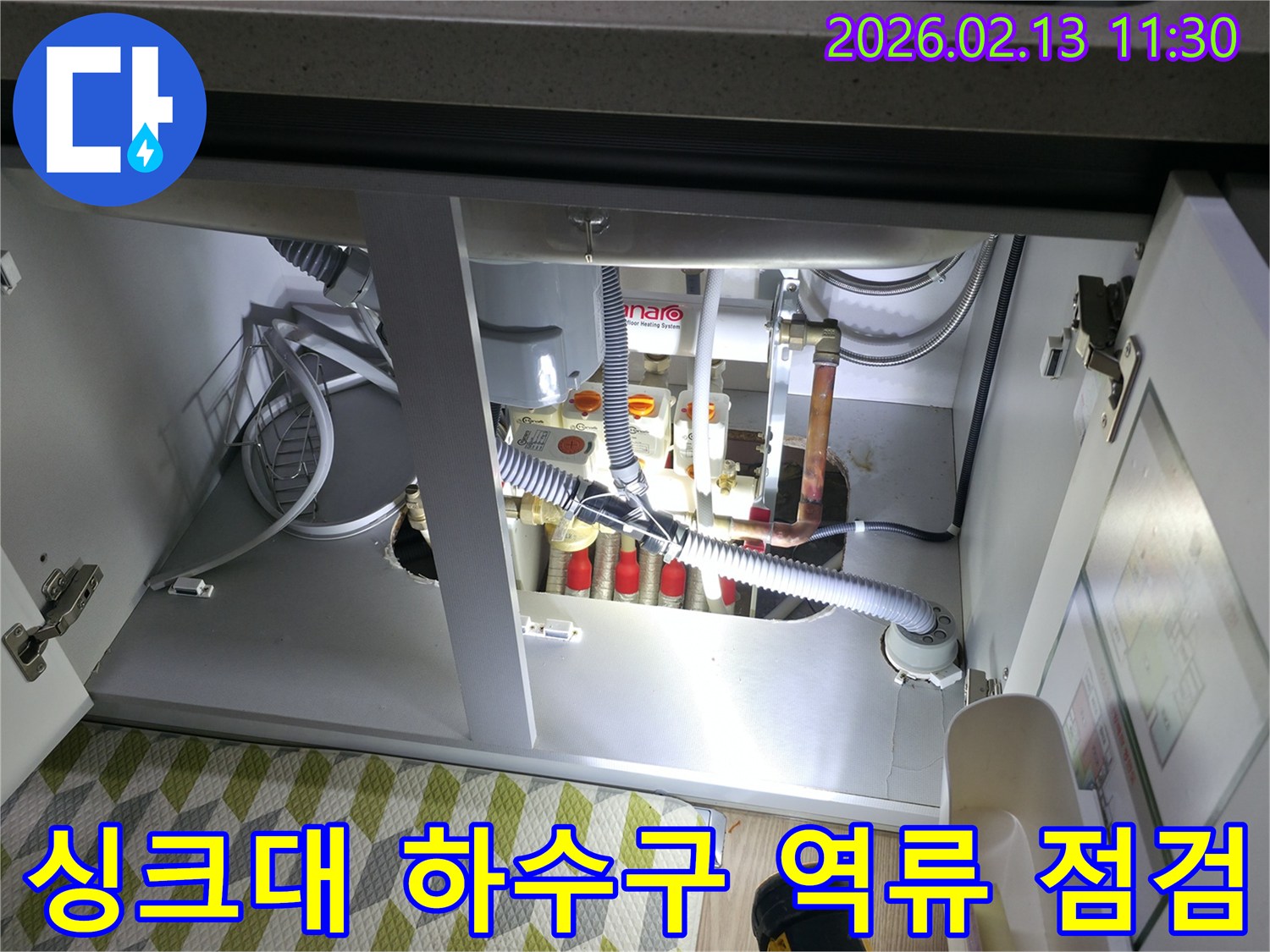 싱크대 하부의 하수구 배관에서-역류 및 누수 문제가 발생하여-전문가가 점검하는 현장