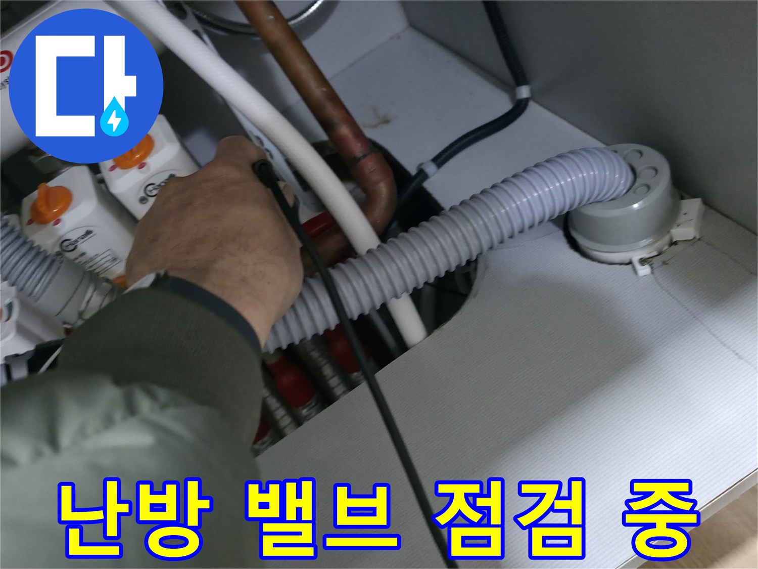하얀색 배관과 분배기 밸브가 연결된 내부를 조사하는 모습