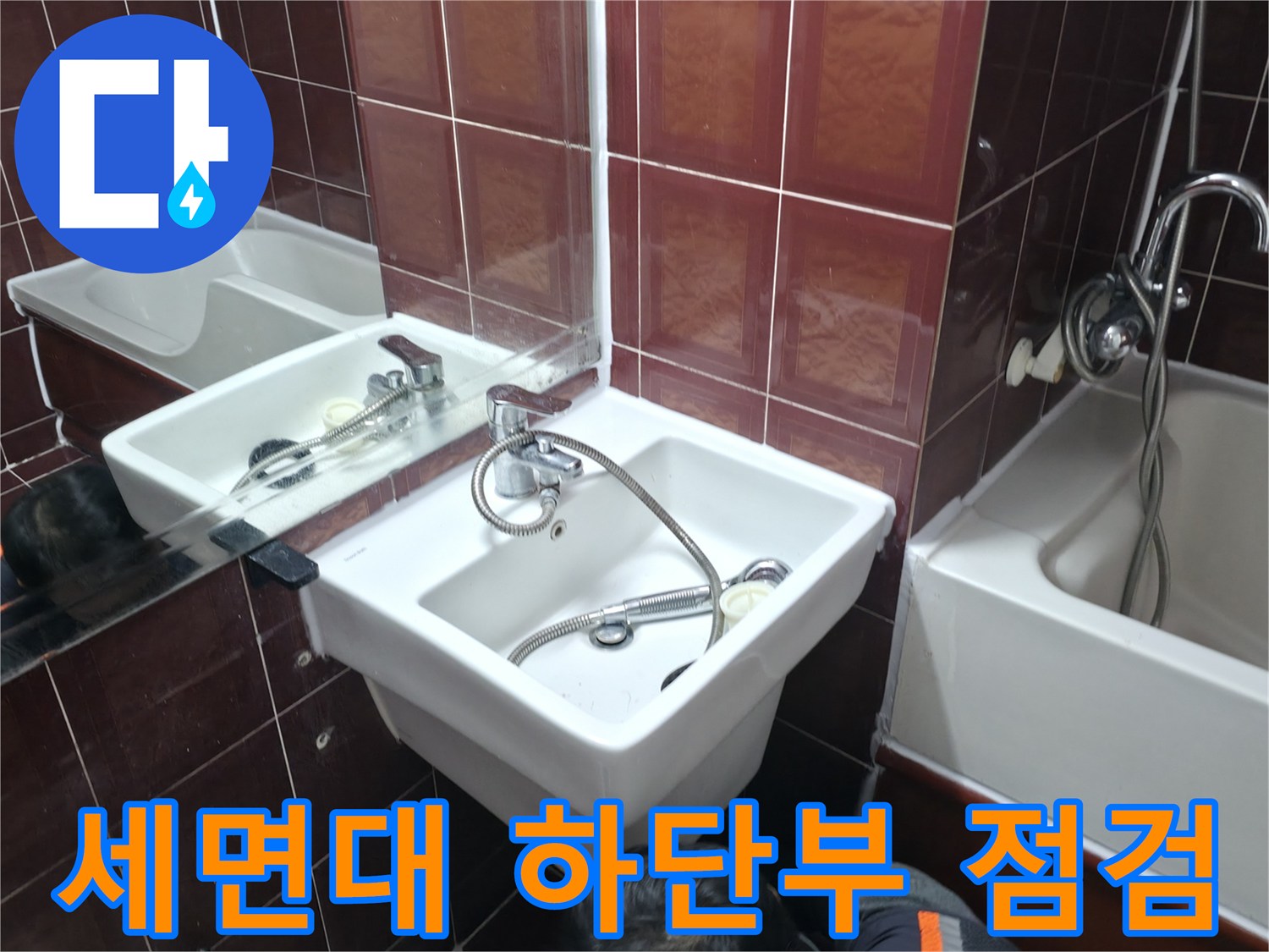붉은색 타일 벽면에 설치된 세면대 수전 사진
