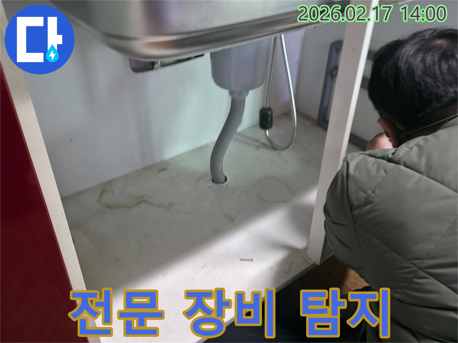 싱크대 하부의-누수 지점을 찾아내기 위해-전문 장비를 활용하여-정밀하게 탐지하는 과정