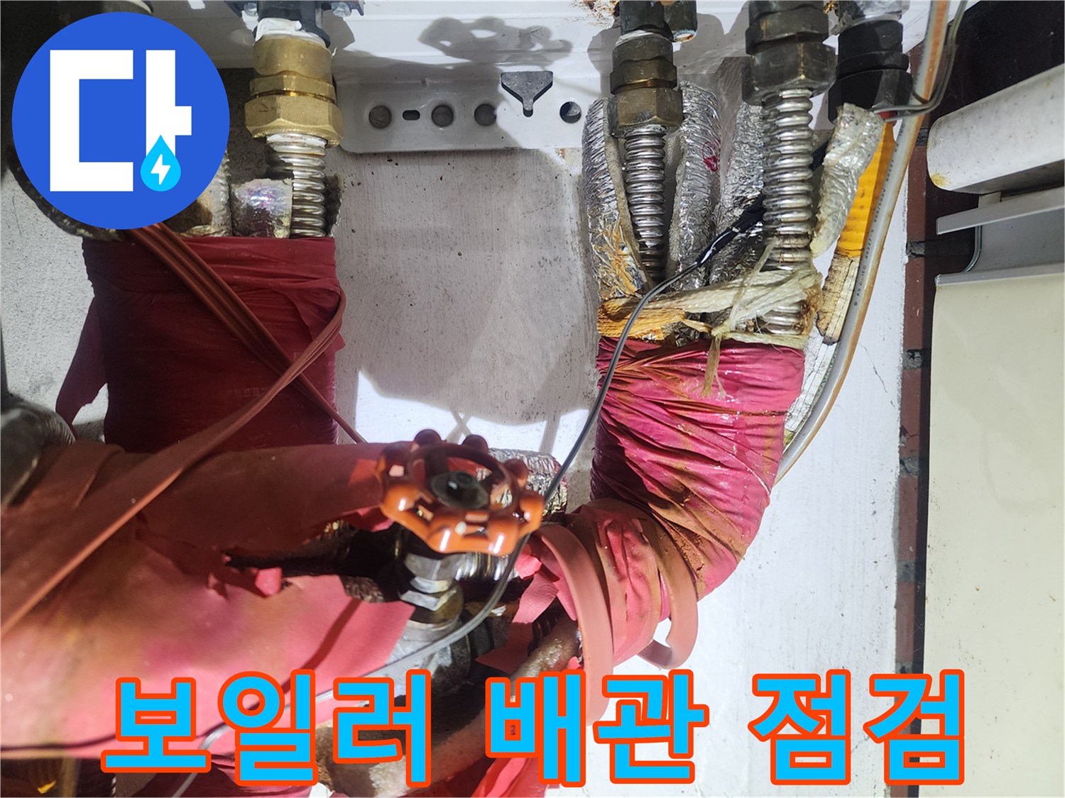 붉은색 보온재로 감싸진-노후된 보일러 배관 연결 부위