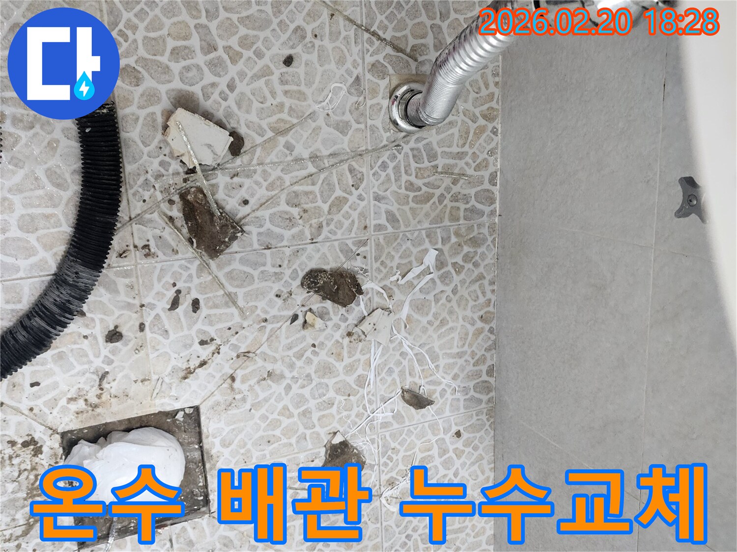 이 이미지는 장한로 주택에서 발생한 온수 배관 누수를 해결하기 위해-전문가가 바닥을 파쇄하고-손상된 배관을 교체하는 공사 현장을 보여줍니다.