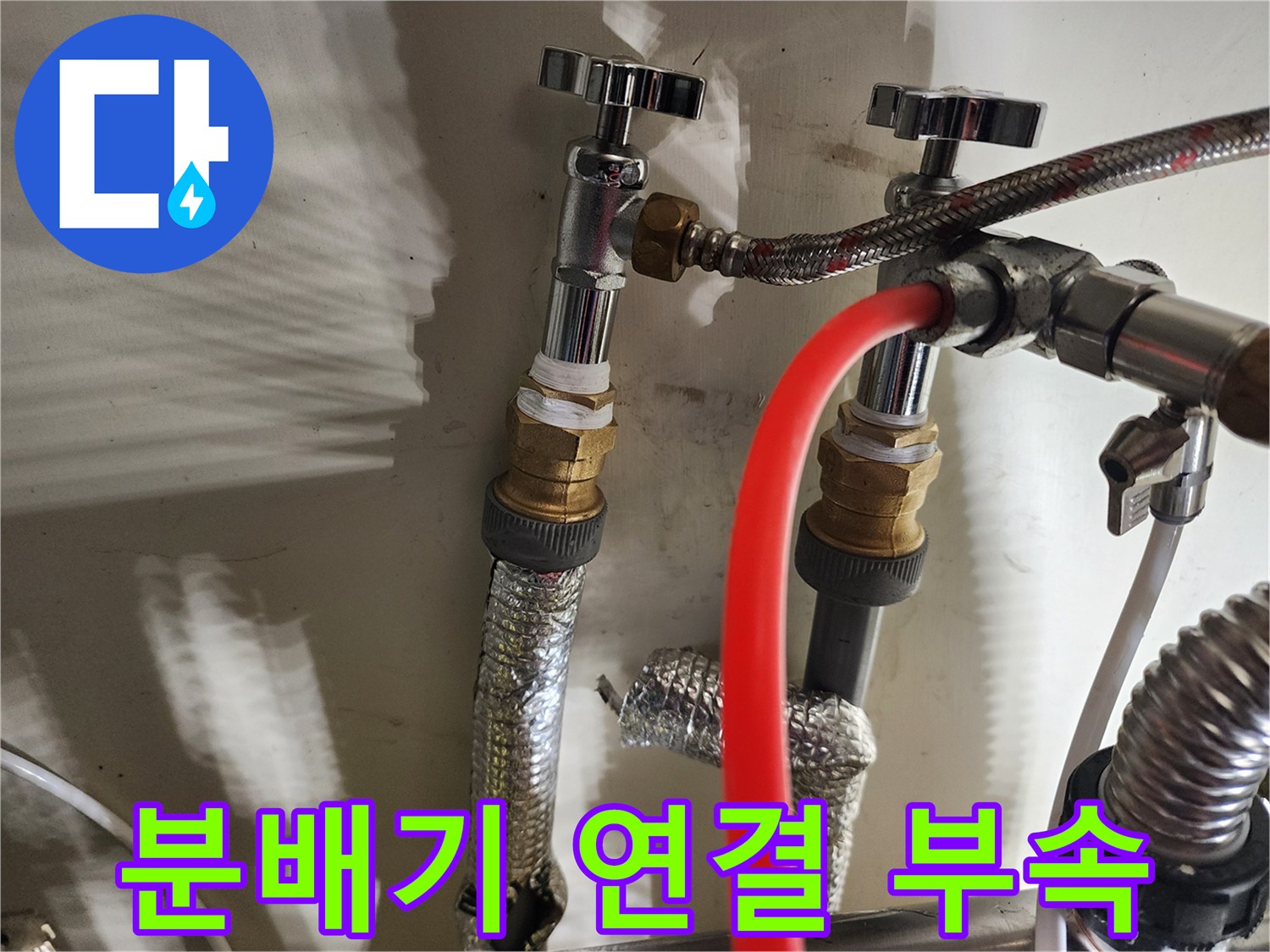 금속 밸브와 호스, 보온재가 포함된 분배기 하단부 사진입니다.