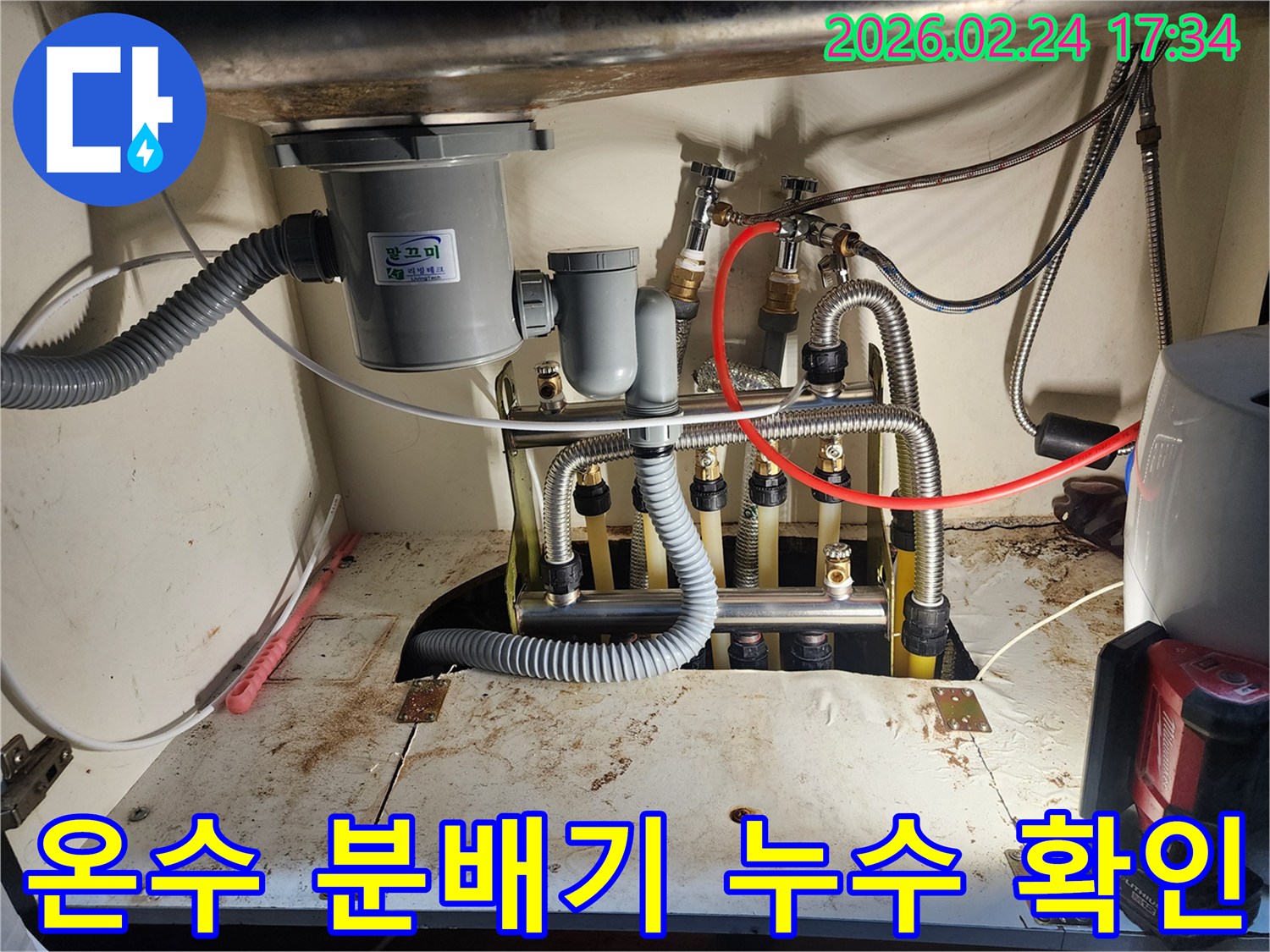 싱크대 하부의-온수 분배기에서-발생한-누수를-정밀하게-확인하고-있는-작업 현장