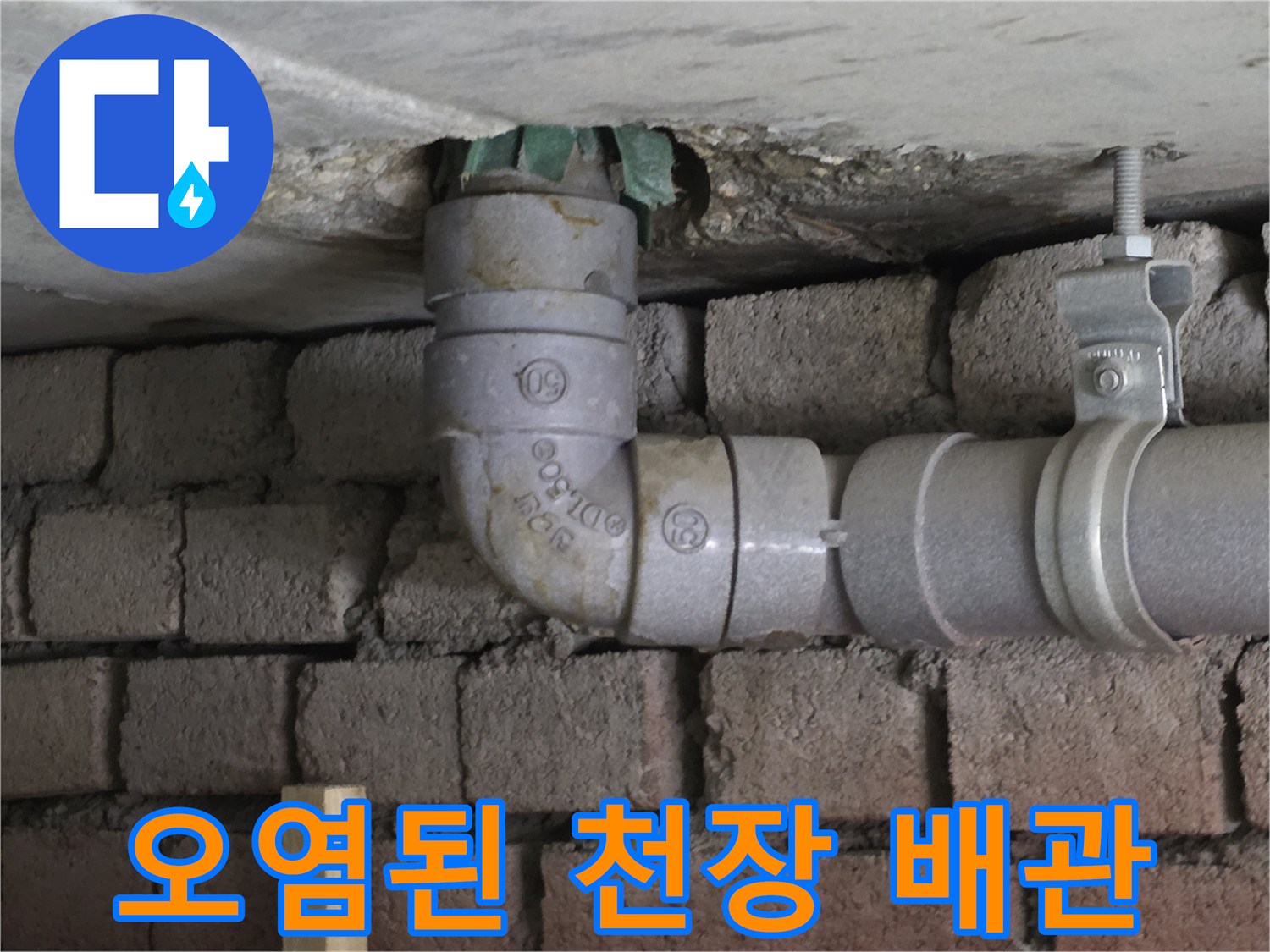 천장 틈새를 통해 보이는 부식된 배관 연결부