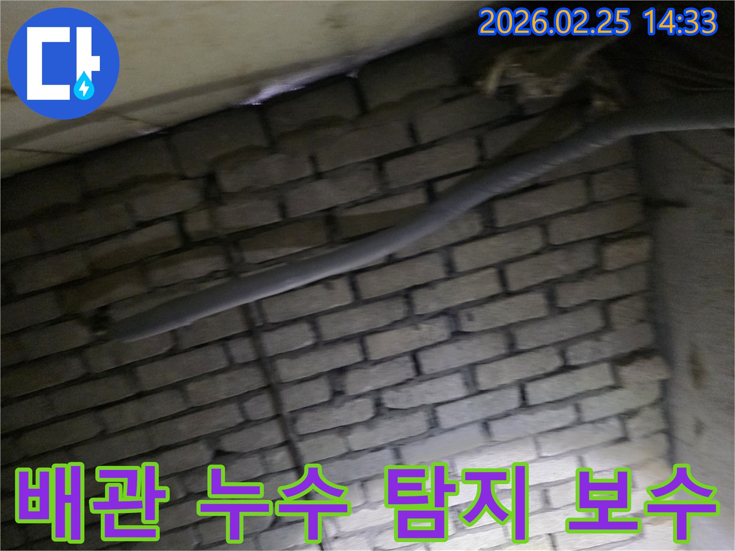 어두운 벽돌 벽면을 배경으로-단열재로 감싸인 배관에서-누수 여부를 탐지하고-보수 작업을 준비하는 현장 이미지입니다.