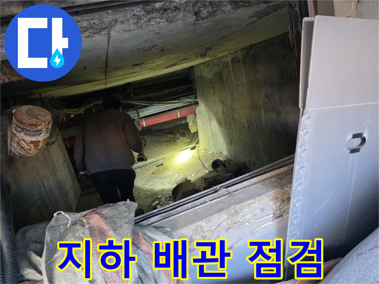 어두운 지하 배관실 내부에서 배관 누수 여부를 진단하는 모습
