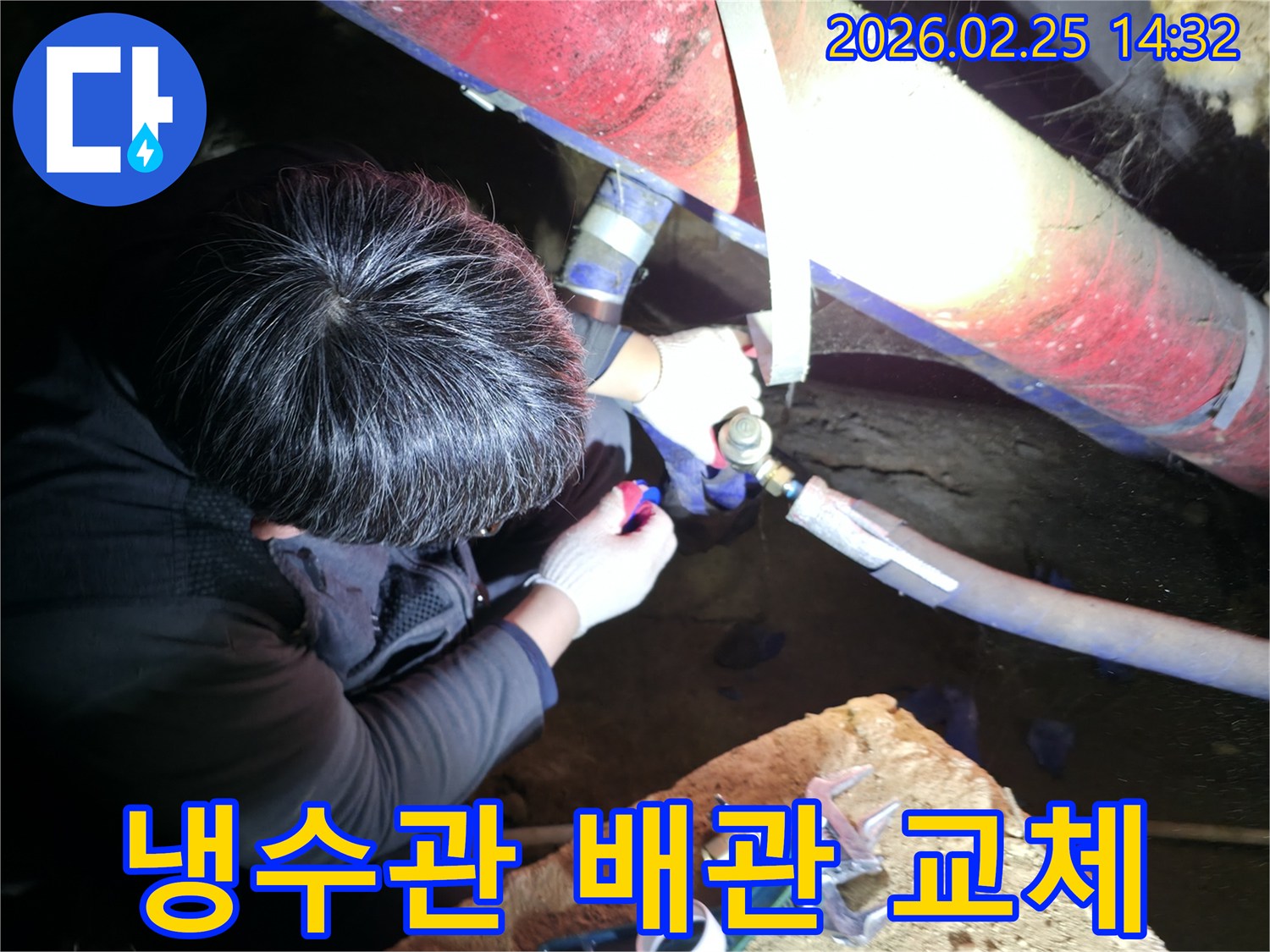 전문 누수 엔지니어가 어두운 작업 공간에서 냉수관 파이프를 정교하게 연결하며 누수 지점을 보수하고 있습니다-정확한수리-배관전문가
