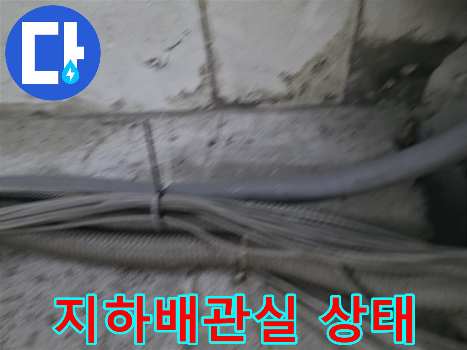 지하 계단 벽면 배관실의 노출된 배관과 오염 흔적