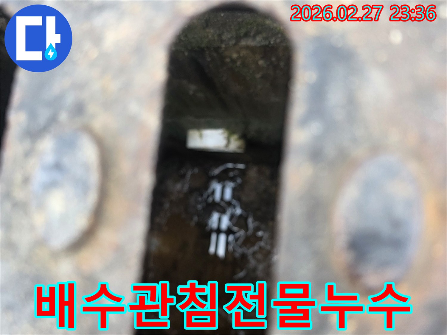 녹슨-철제-배수구-아래-고인-물과-물속에-잠긴-하얀-침전물이-보이는-배수관-누수-현장-사진
