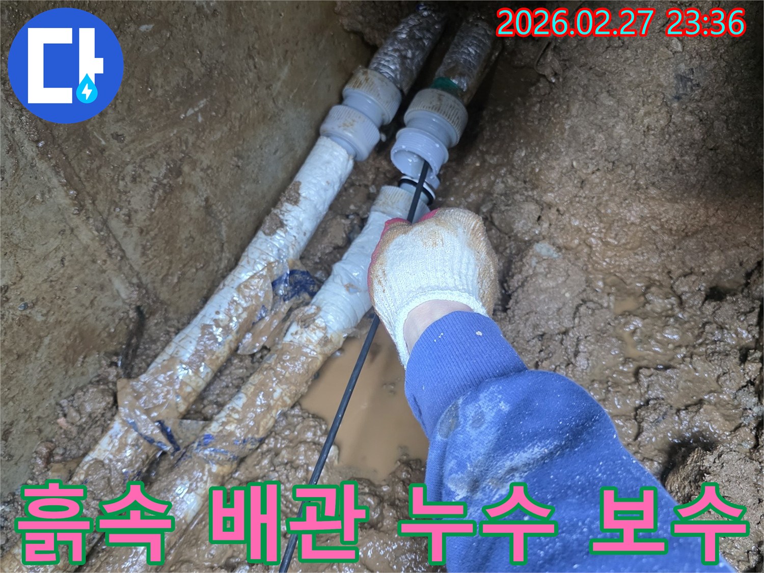 흙 속에 묻힌 수도관에서 발생한 누수를-전문가가 정밀하게 보수하는 현장 사진입니다