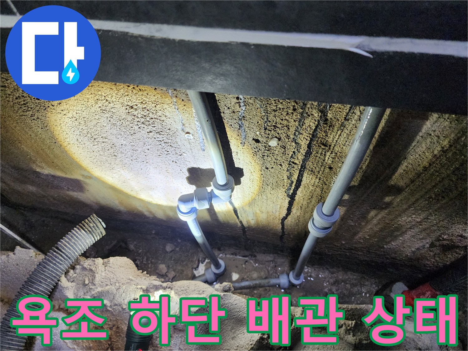 욕조 아래쪽-습기로 얼룩진 벽면과 배관의 모습