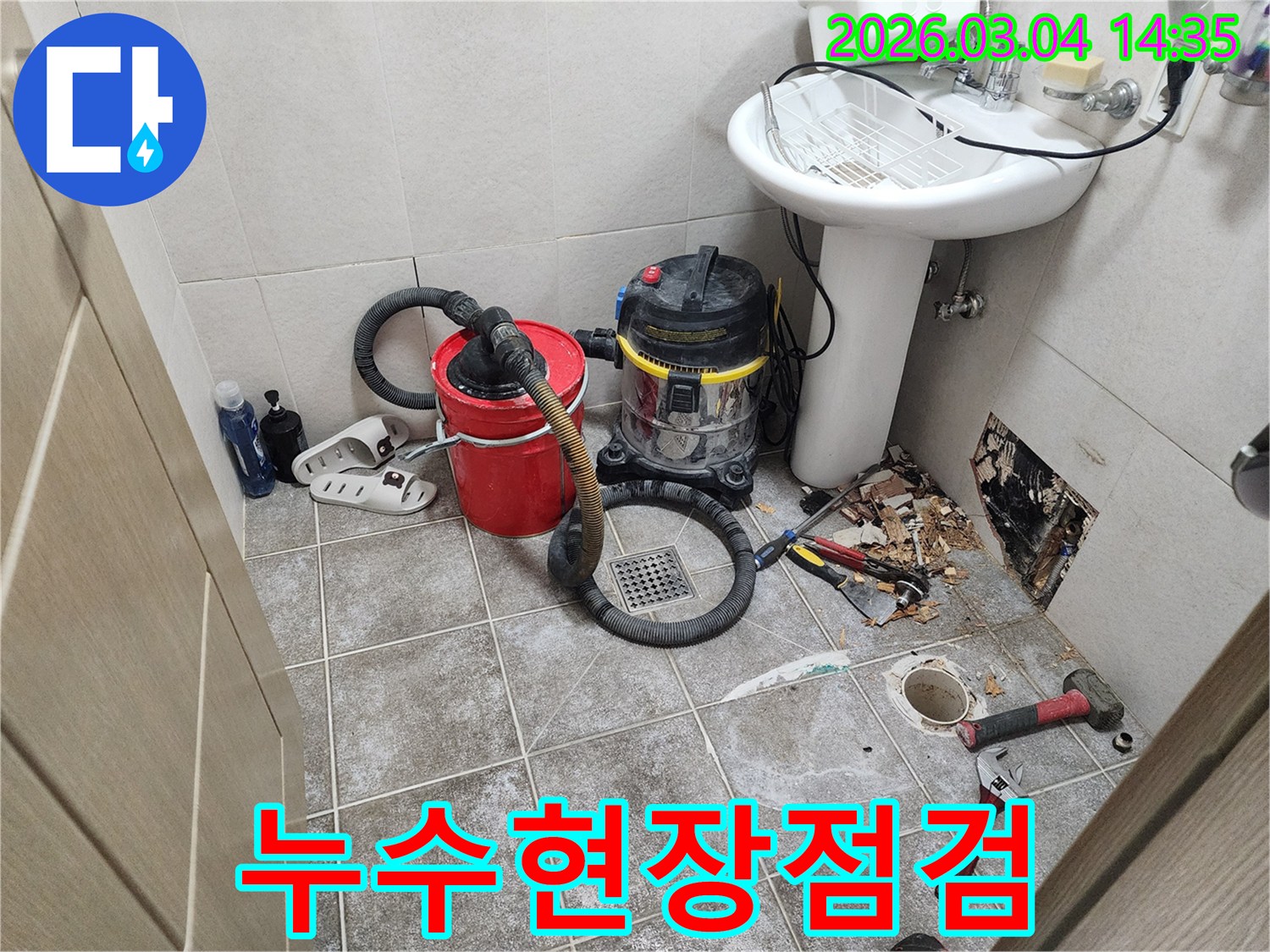 누수된 물을-제거하고-배관 압력을-테스트하기 위해-설치된-전문 장비들이-욕실 바닥에-놓여 있습니다