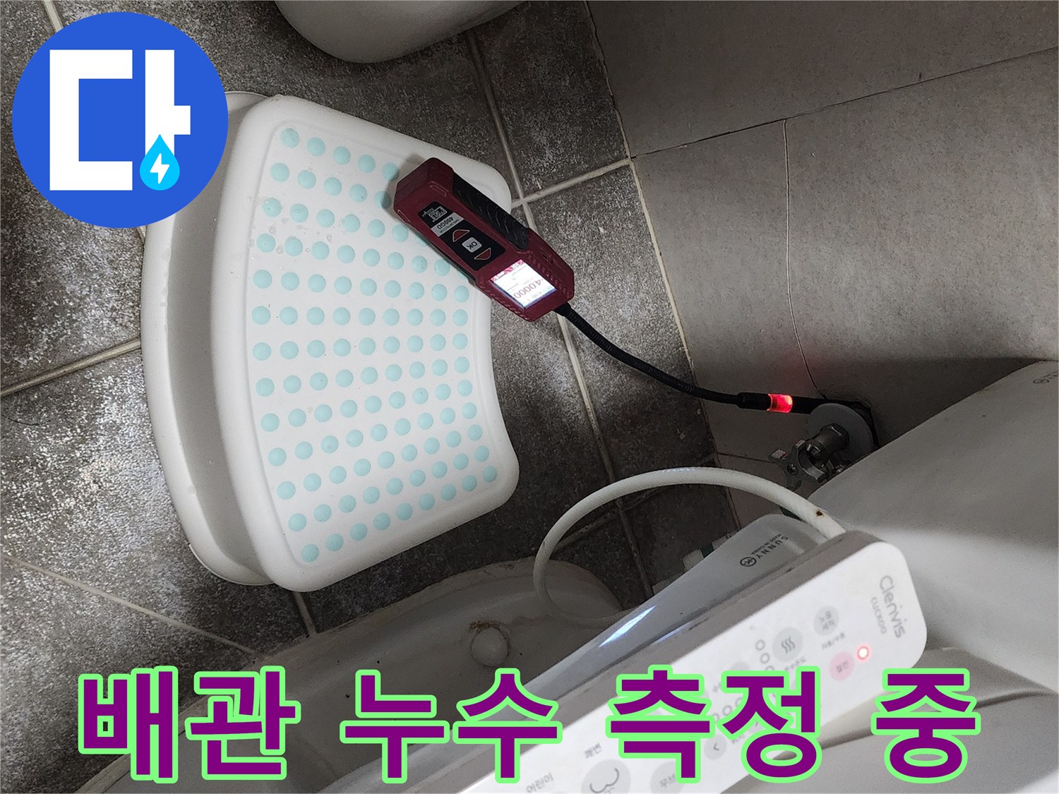 변기 하단 바닥에서-전류식 탐지기로 배관을 검사하고 있습니다.