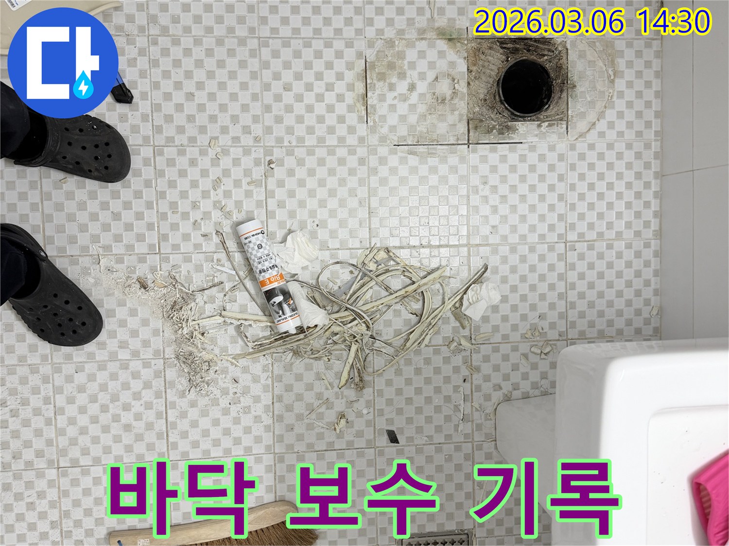 아파트 화장실 바닥의-누수 보수 전 상태를 기록하며-오염된 배수구 주변과-제거된 마감재를 보여주는 모습