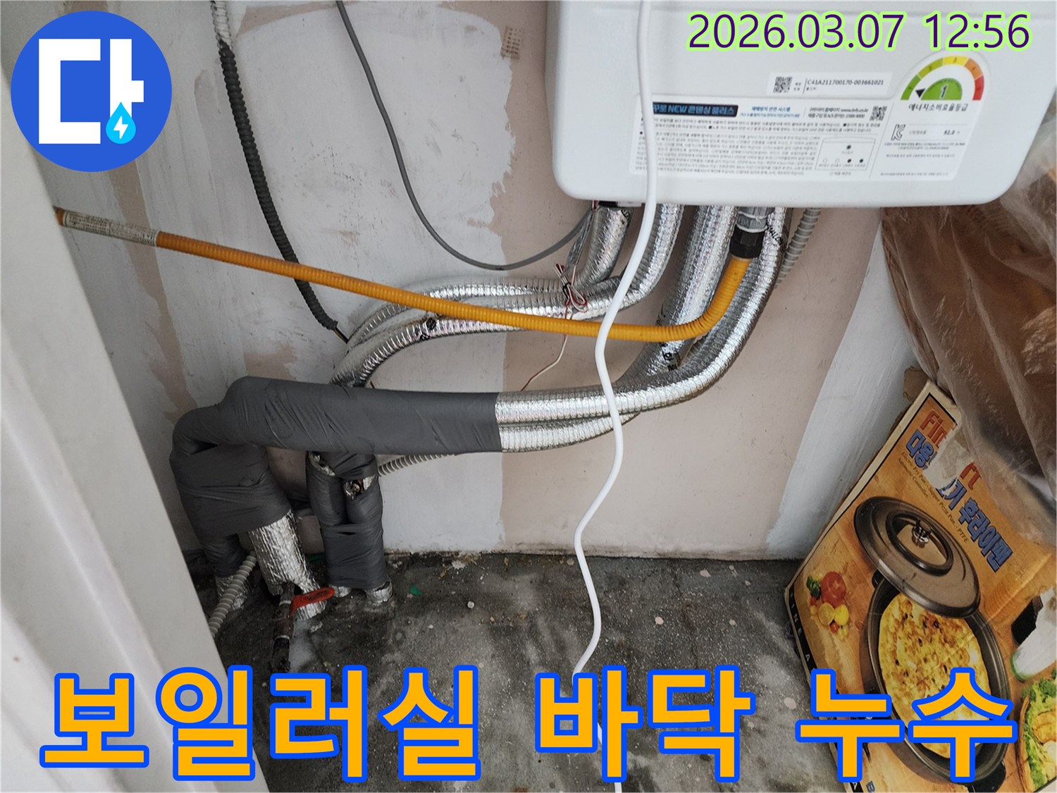 보일러실-바닥에-물이-고인-누수-현장을-전문가가-점검하는-사진입니다