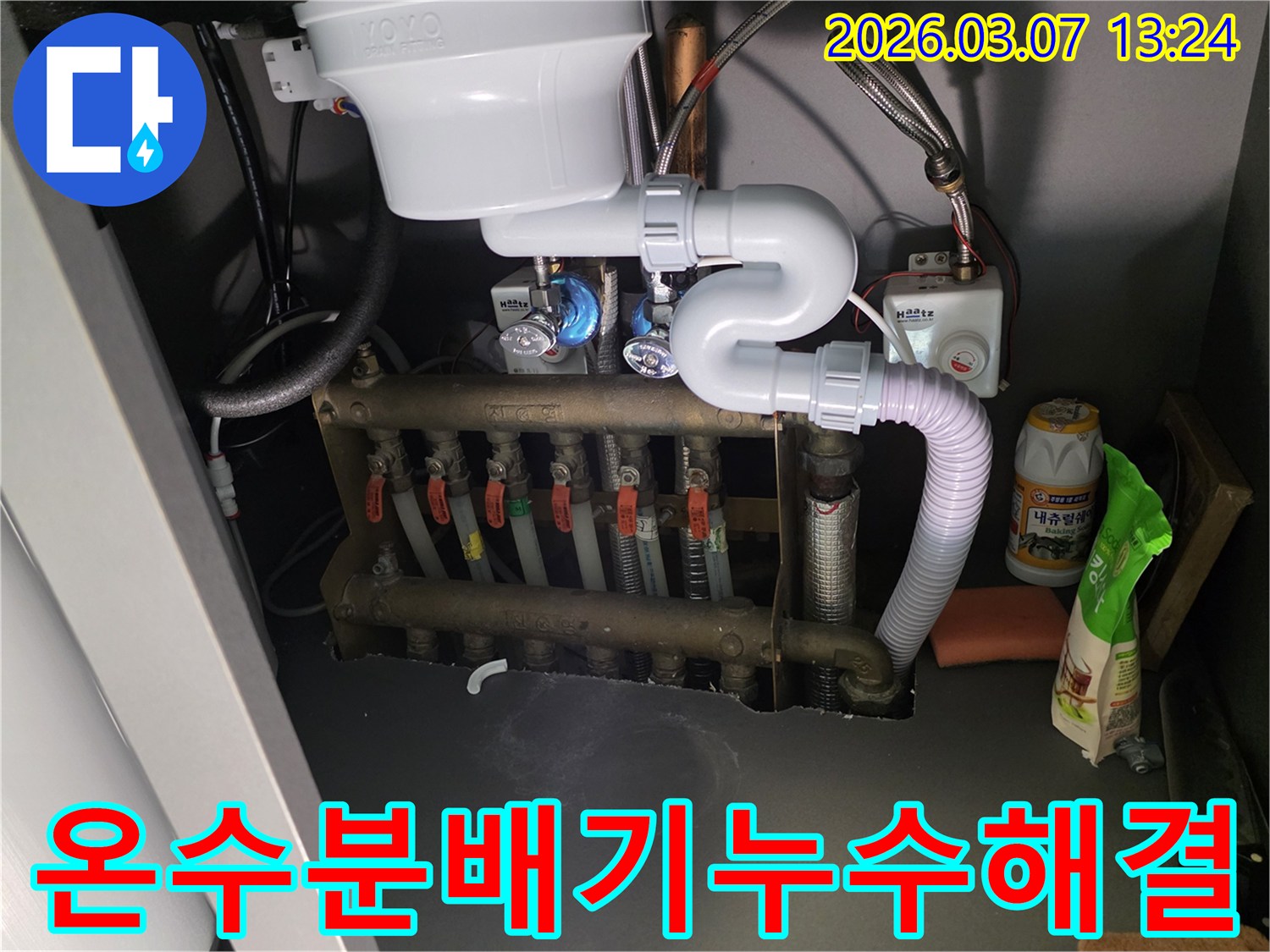 아파트 싱크대 하부-온수 분배기에서-발생한 누수를-전문가가 해결하는 모습