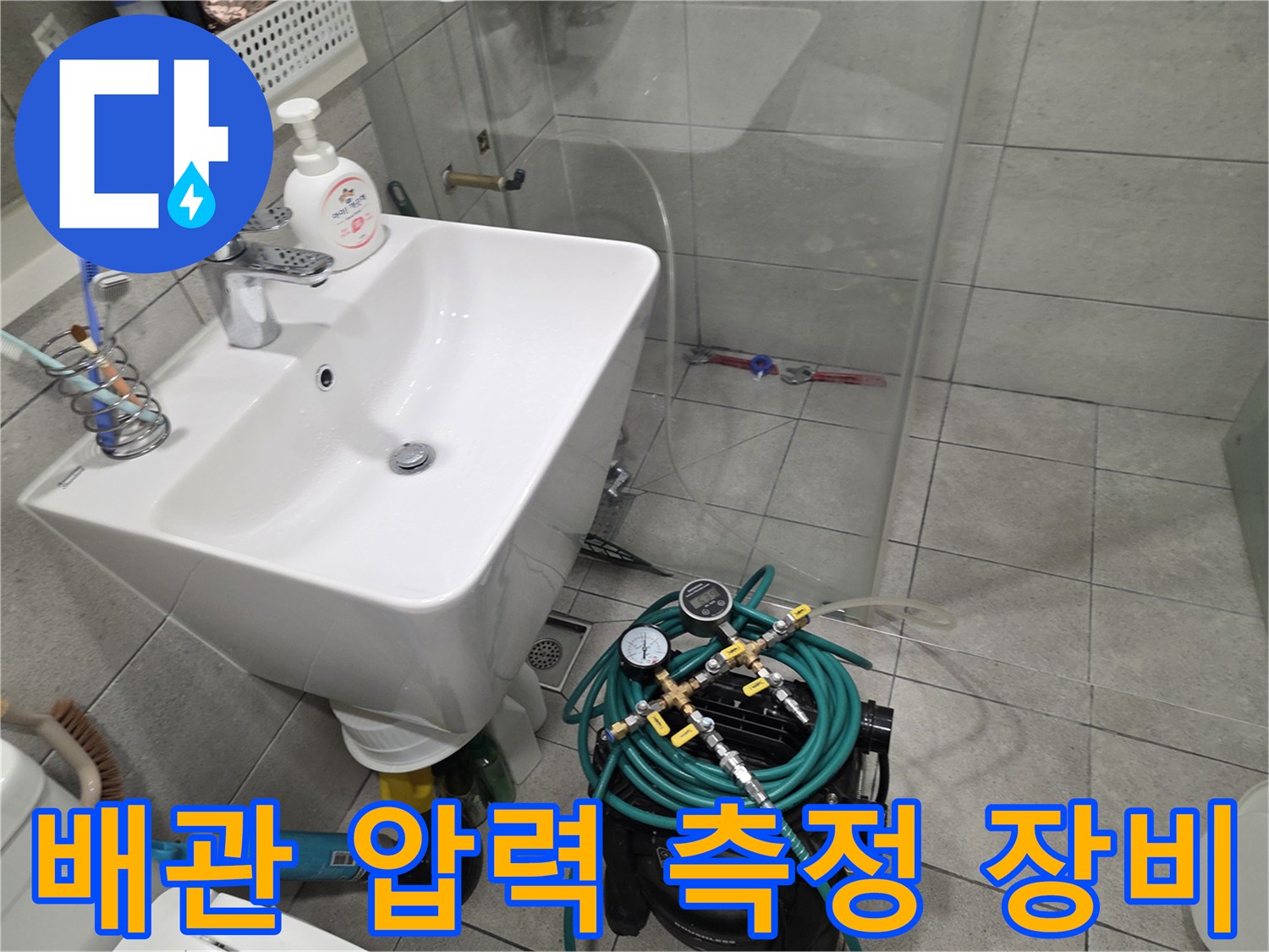 욕실 세면대 하부-공압 테스트를 위해 연결된 호스와 게이지