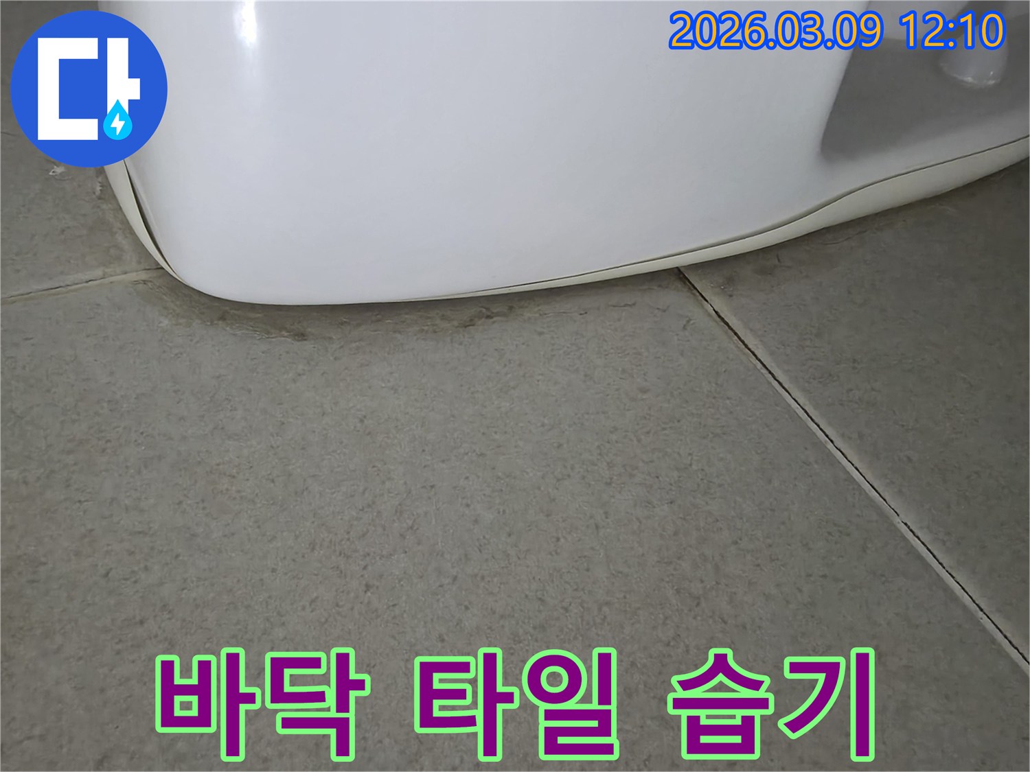 화장실 변기 아래-바닥 타일에-습기가 스며들어-생긴 어두운 얼룩은-누수 발생을-시사하는 명확한-증거입니다