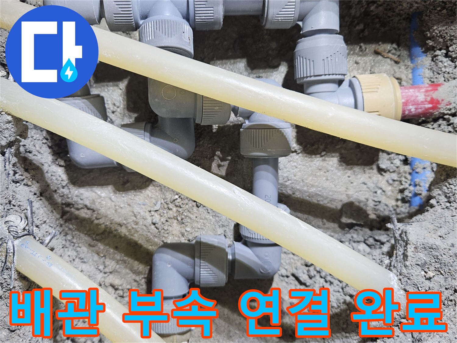 새로운 배관과 연결 부품이 정렬된 굴착 현장 사진