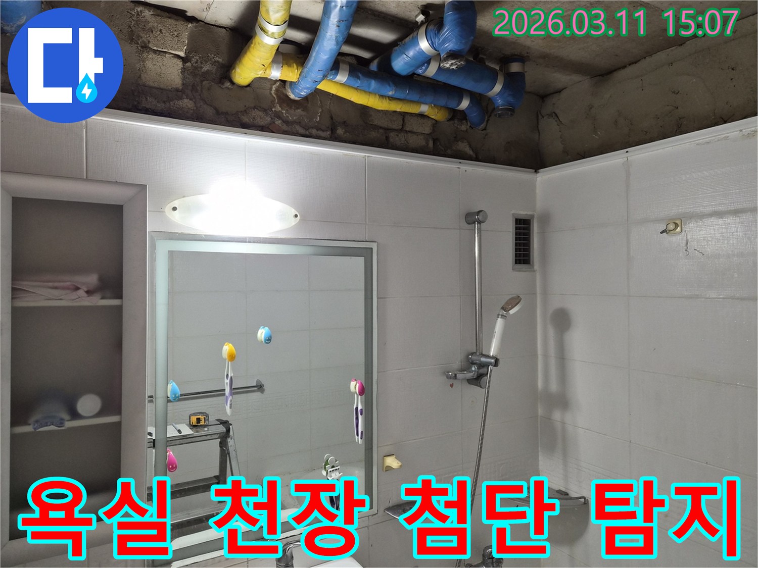 욕실 천장 내부의-파란색과 노란색 배관들이-첨단 기술로-숨은 누수 지점을 탐지하기 위해-노출된 모습