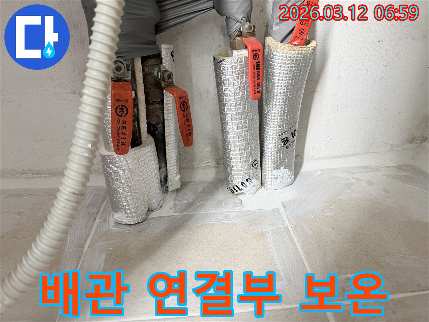 누수-공사-중-배관-연결부에-보온재를-꼼꼼하게-감싸는-모습