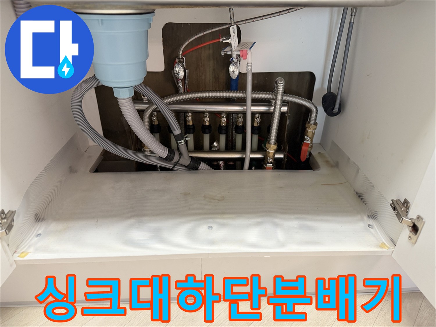싱크대-밑부분의-난방-분배기와-연결된-여러-개별-배관들