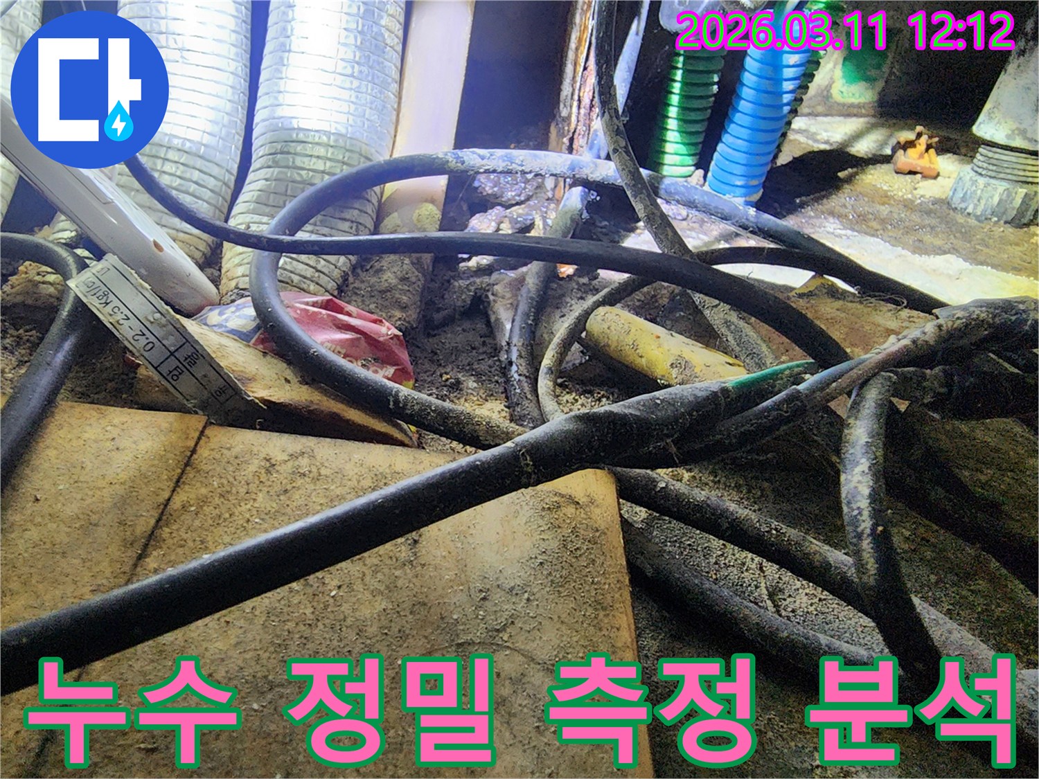 누수-현장에서-배관과-전선-사이의-복잡한-환경에서-정밀한-측정을-위해-사용된-도구를-보여주는-사진입니다.