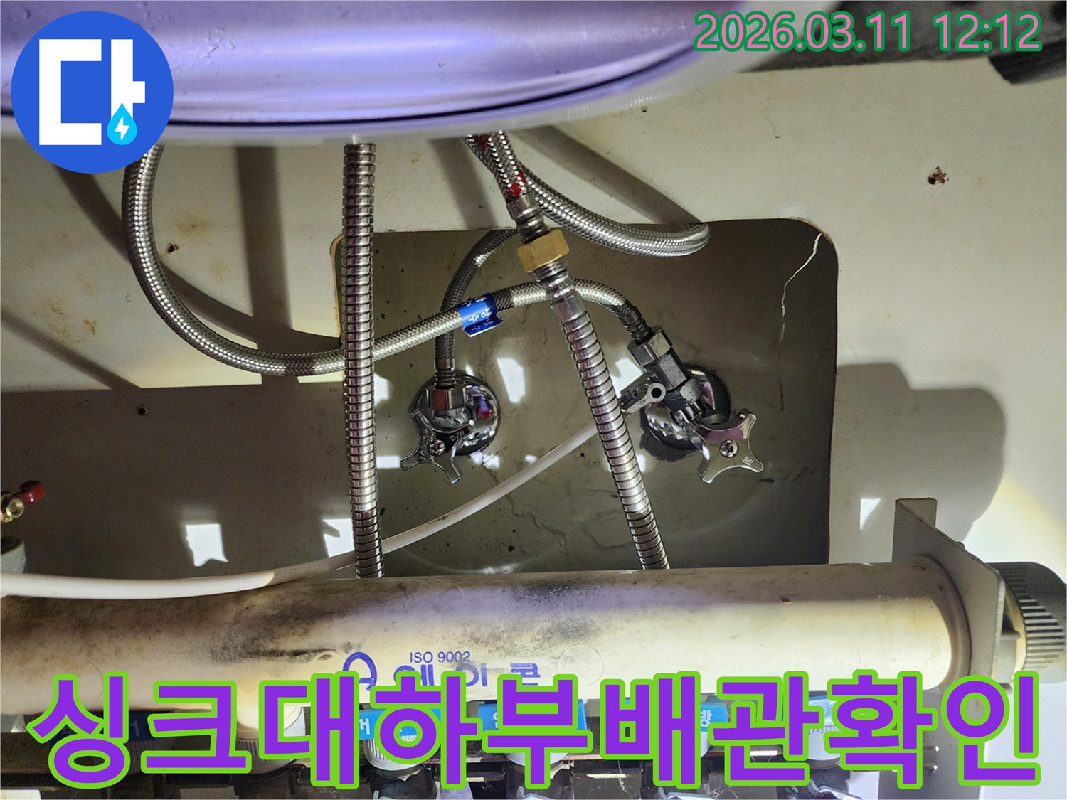 다수의-수도-배관과-밸브가-복잡하게-얽혀있는-싱크대-아래쪽-부분을-확대한-이미지