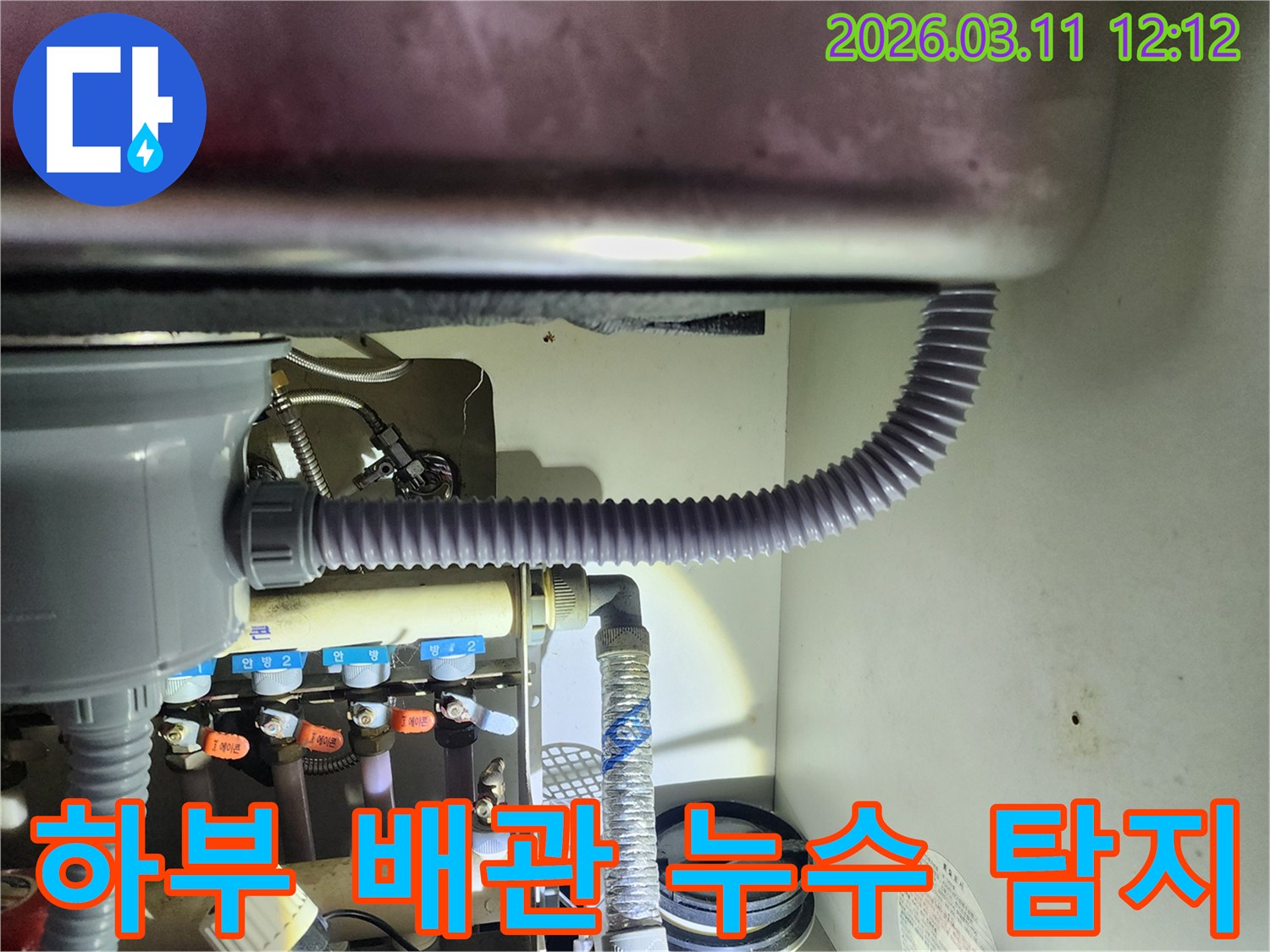 싱크대 하부의-복잡한 배관 시스템에서-누수 지점을-정확히 찾아내기 위한-탐지 작업을-진행하는 모습입니다
