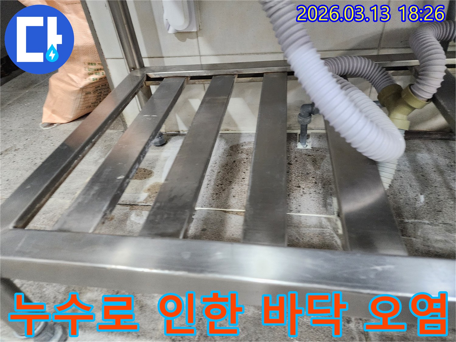 누수-현장에서-스테인리스 선반 아래-오염된 바닥과-배관 연결부를-자세히 살펴보는-탐지 과정
