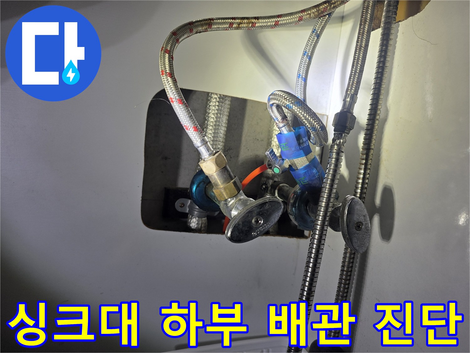 싱크대 아래쪽 - 물이 새는 밸브와 금속 호스 연결 부위 상세 촬영