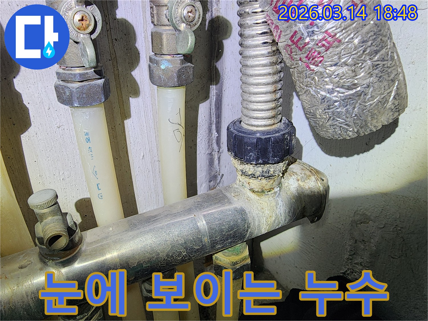 배관 연결 부위에서-물이 새어 나와-석회 침전물이 형성된 모습