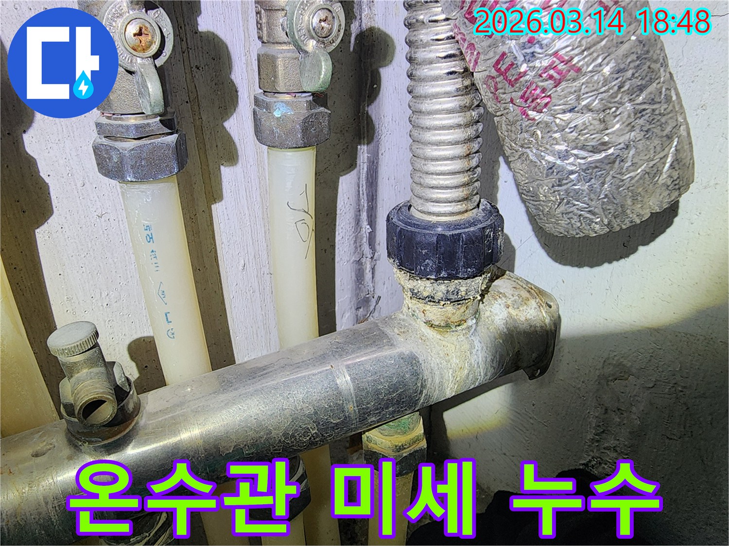 온수관 연결 부위에서-미세한 누수로 인해-석회 침전물이 생긴 모습