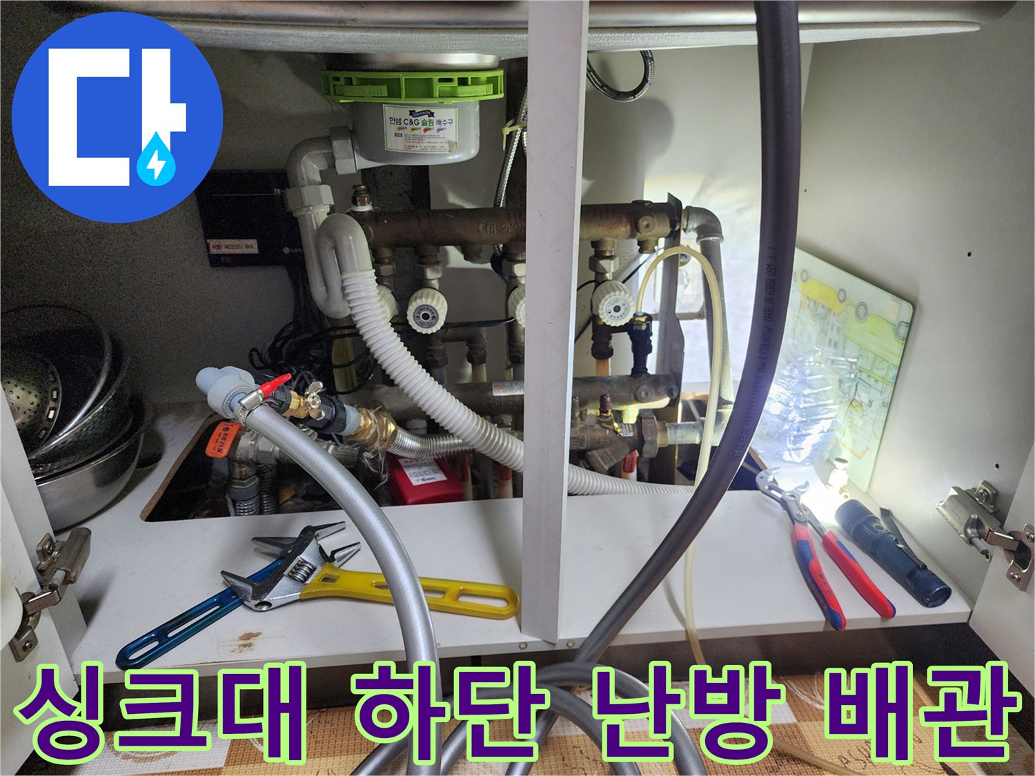 싱크대-내부-하단에-위치한-난방-분배기-및-연결-배관들