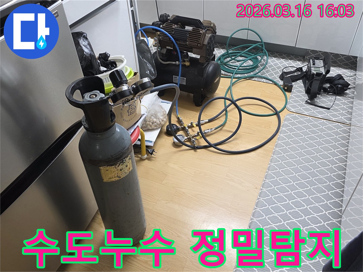 수도관 누수 원인을 정확히 찾아내기 위해-질소 가스통과 압축기를 연결하여-정밀 탐지를 준비하는 현장입니다