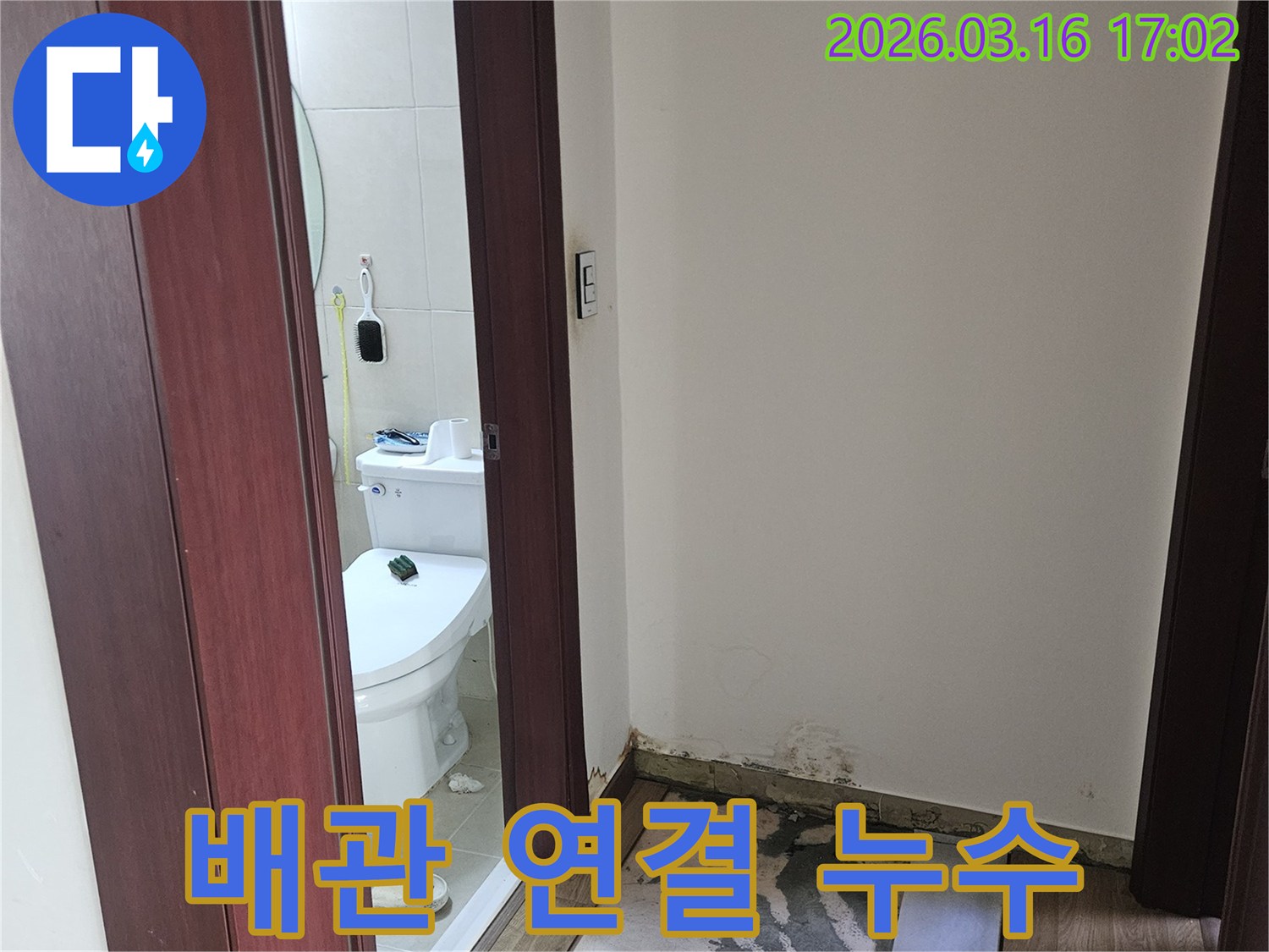 화장실 배관 연결 부위에서-누수가 발생하여-인접한 벽면과 바닥이-손상된 현장 사진입니다