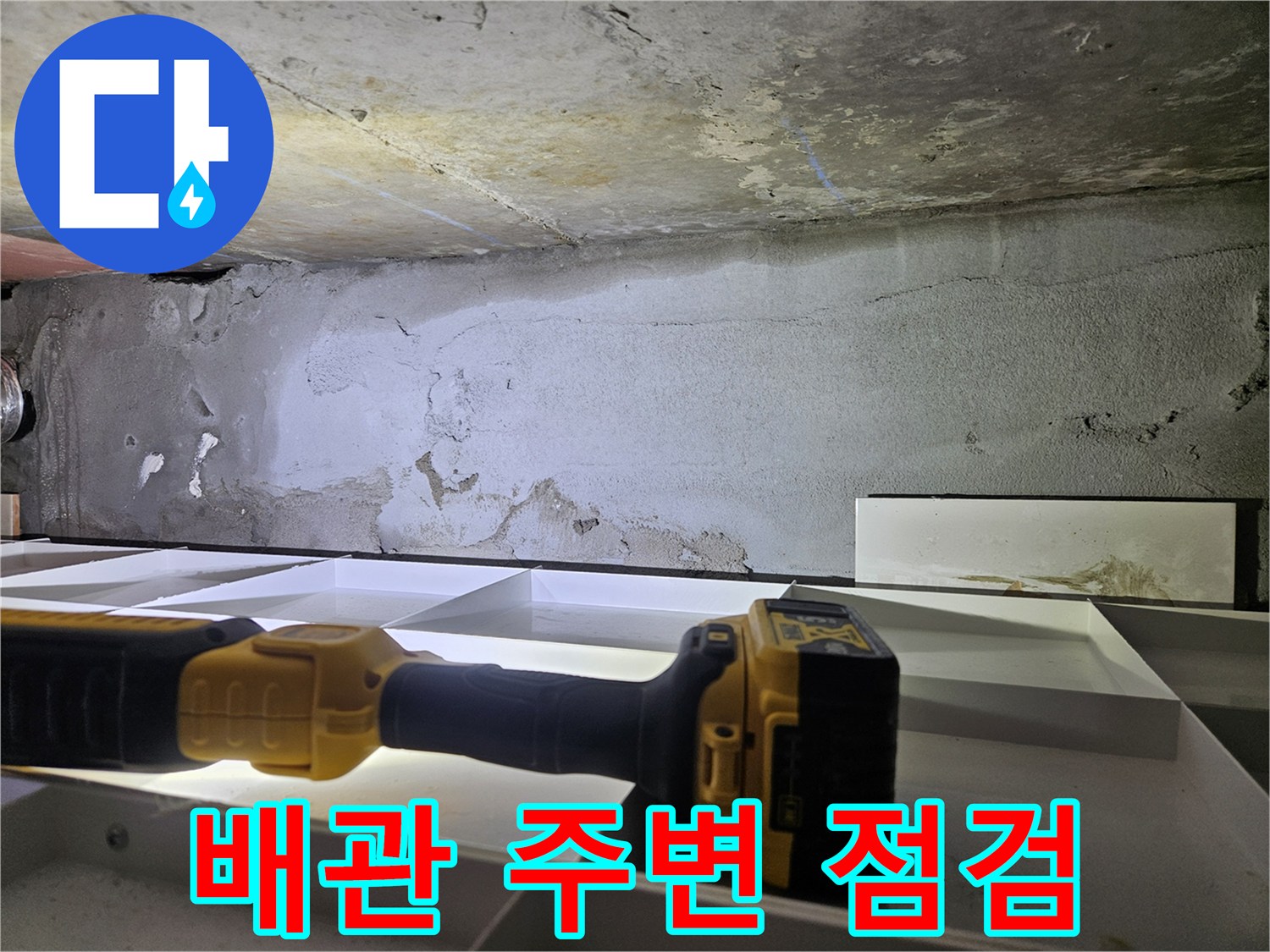 누수 점검을 위해 손전등으로 비춘 배관 부위 벽면 상태