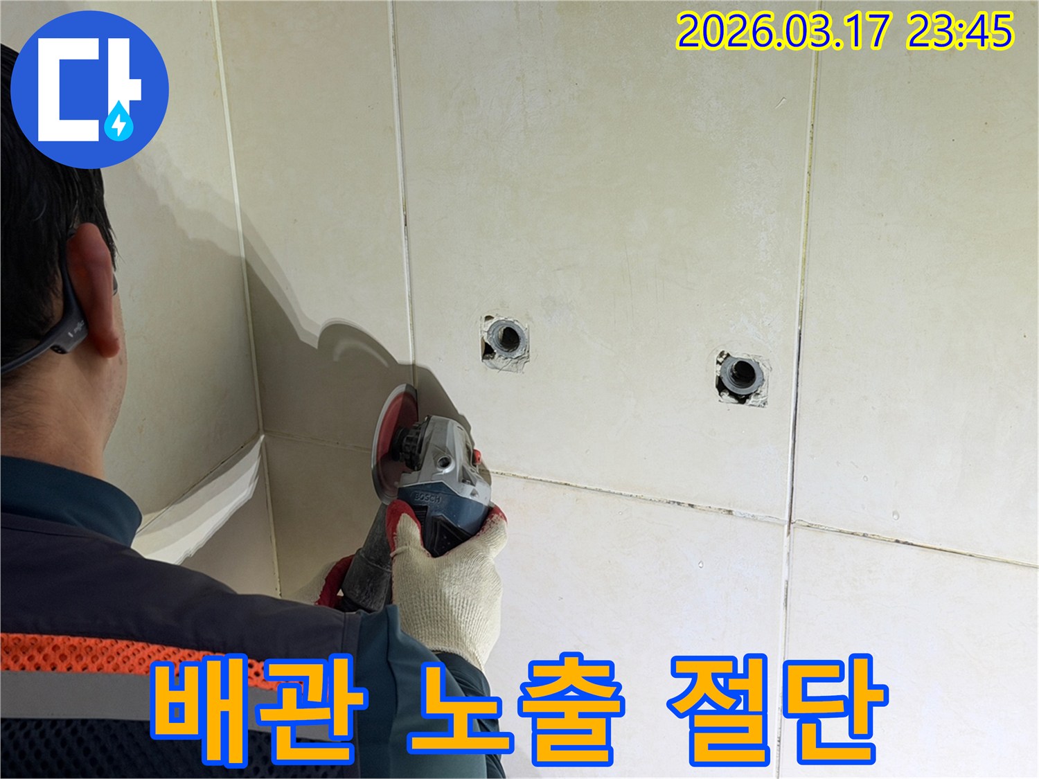 누수된 배관을-노출시키기 위해-전문가가-타일 벽면을-그라인더로-조심스럽게-절단하고-있습니다